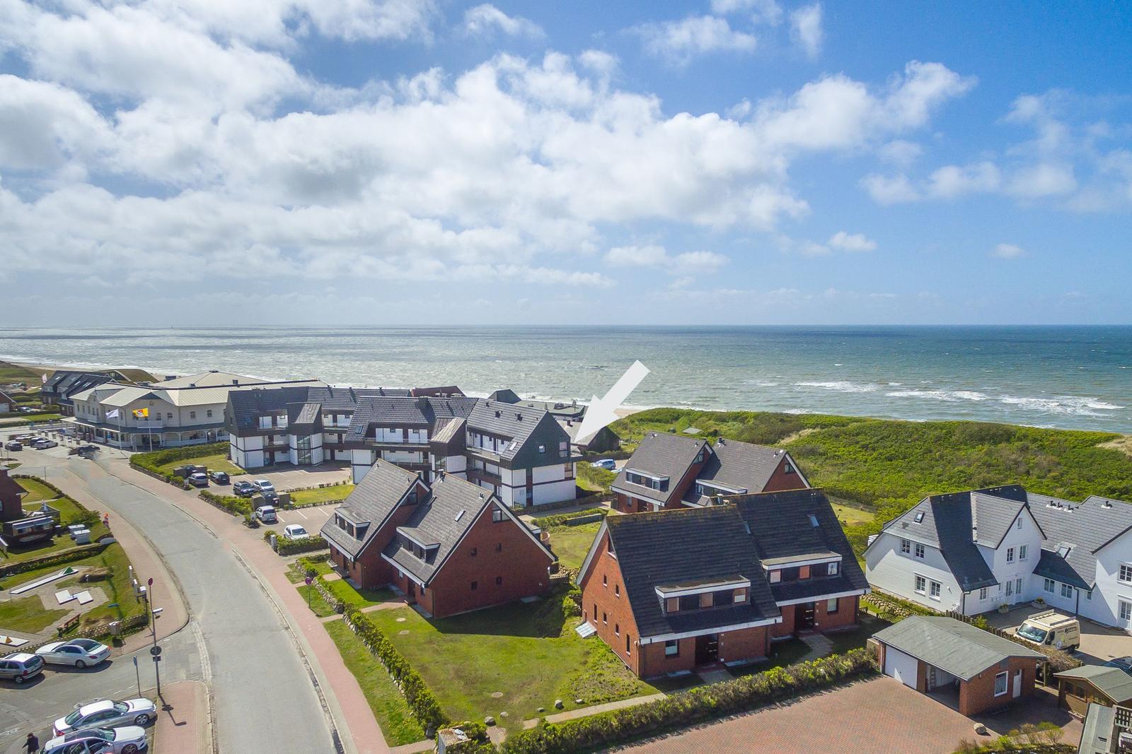 Coastal village with houses and beach. Aerial view of the seaside landscape.