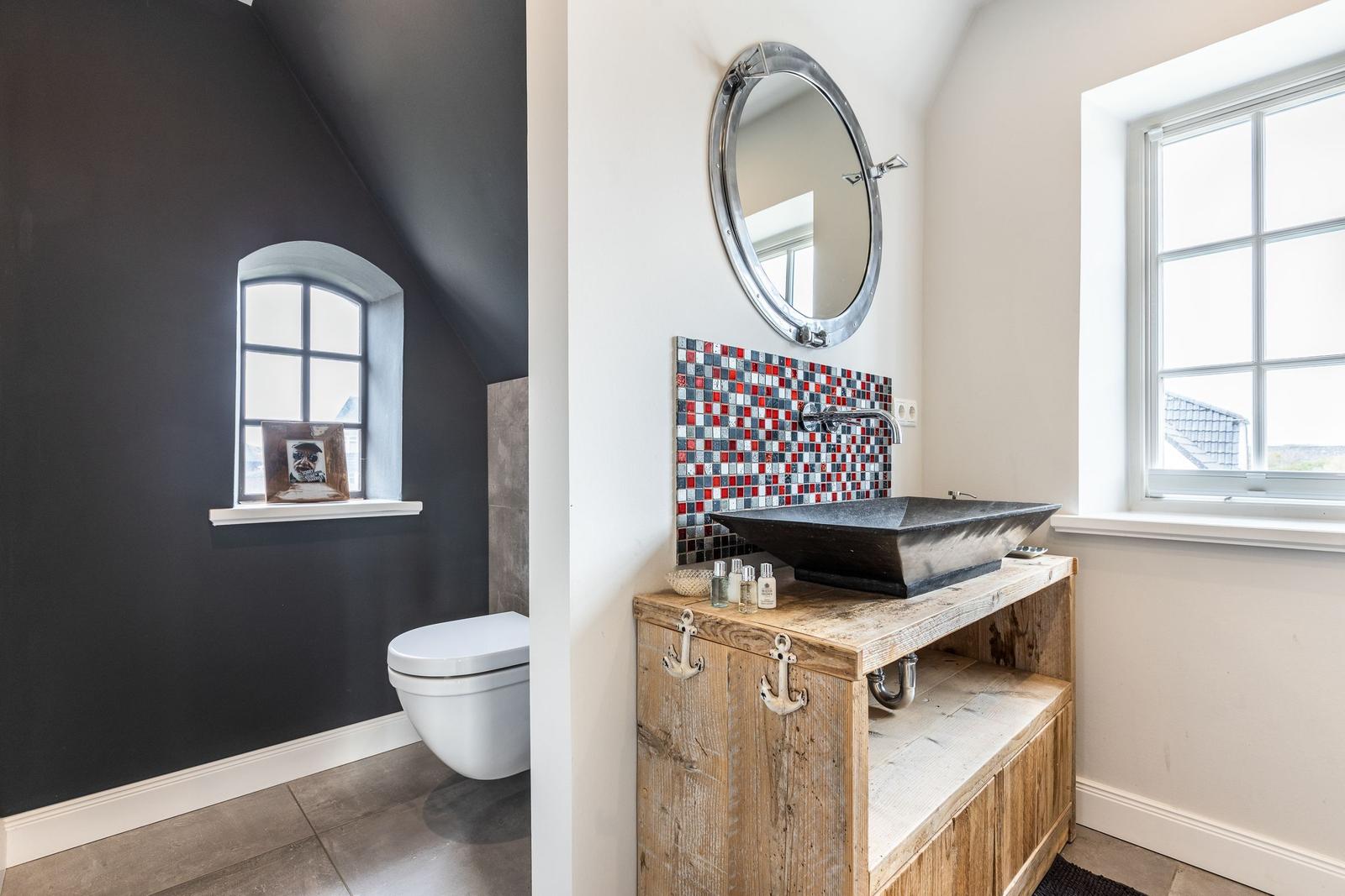 Bathroom with sink on wooden console, mirror, and window
