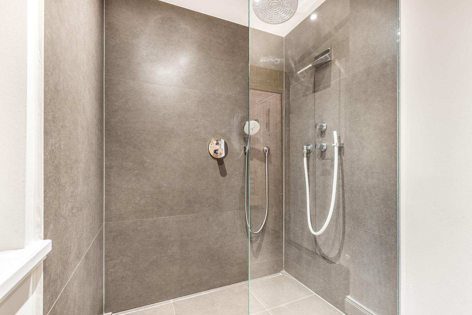 Shower cabin with glass enclosure and modern shower fixtures.