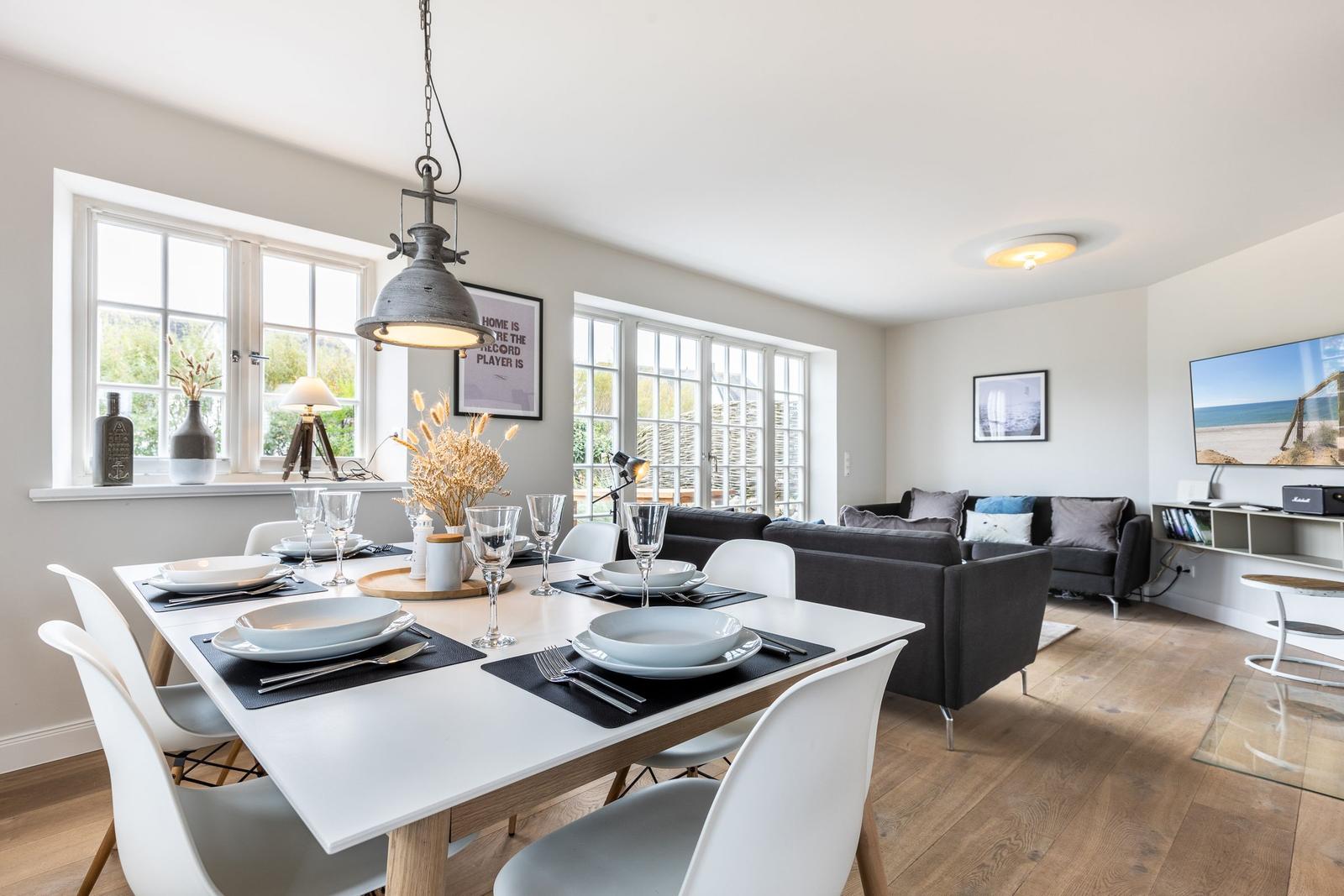Dining area with table and chairs, living area with sofa and TV