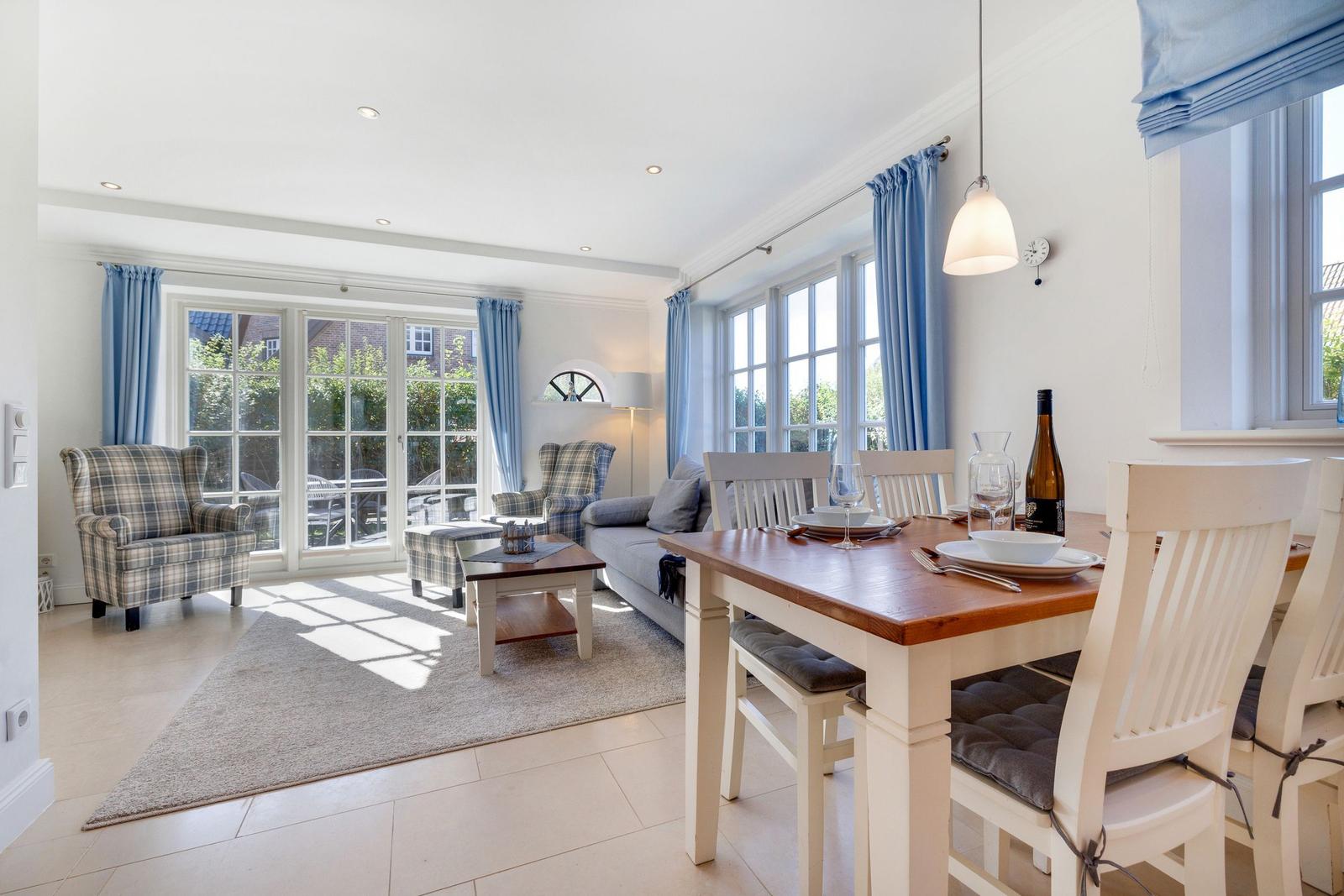 Wohn- und Essbereich mit Tisch, Stühlen, Sofa und Blick auf Garten