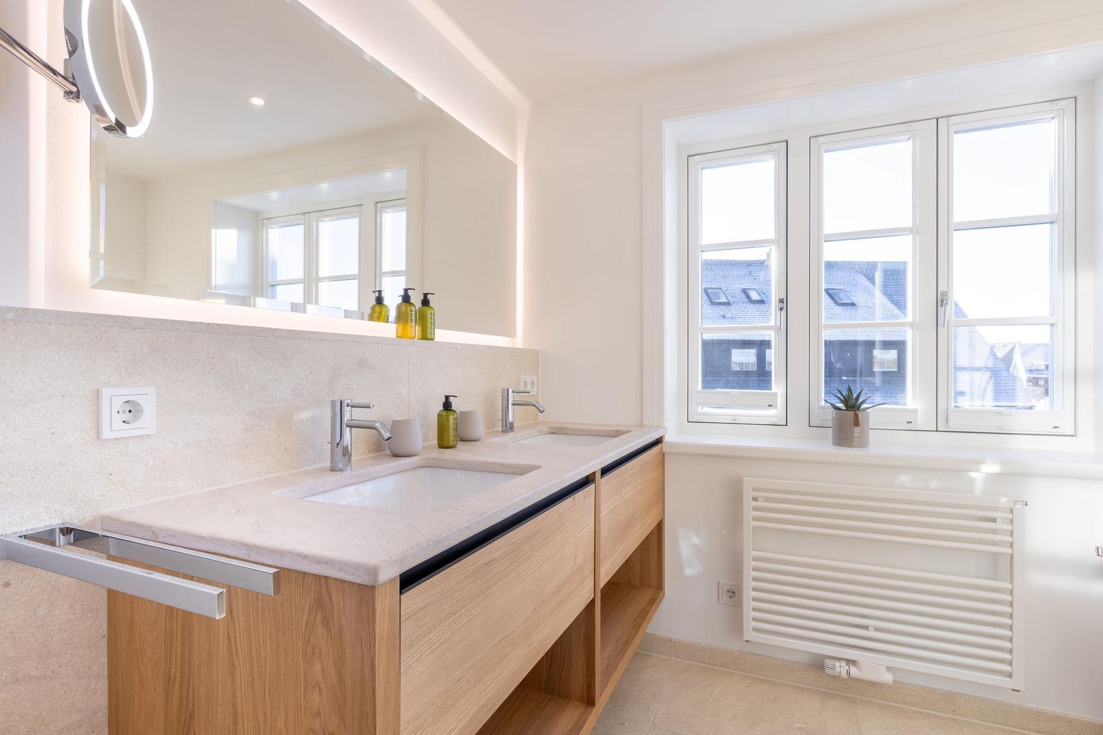 Badezimmer mit Doppelwaschbecken, Spiegel und Fenster