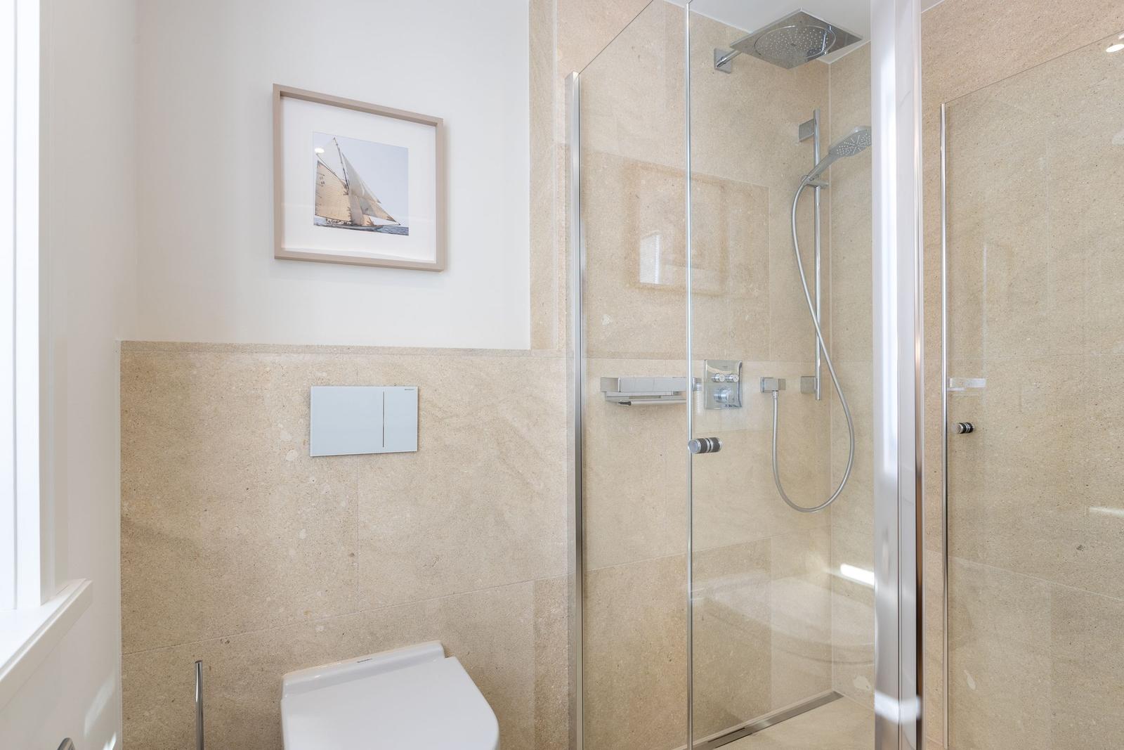 Badezimmer mit Dusche und Toilette, Wandbild und Fliesen