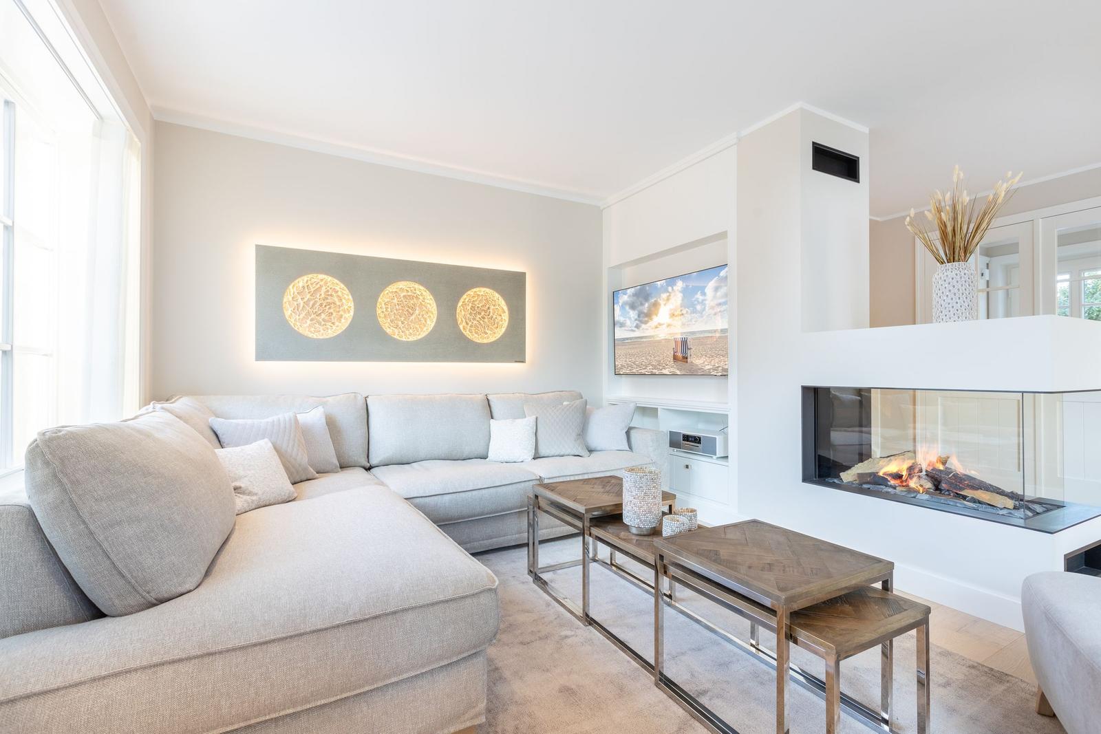 Wohnzimmer mit Sofa, Kamin und Fernseher an der Wand.