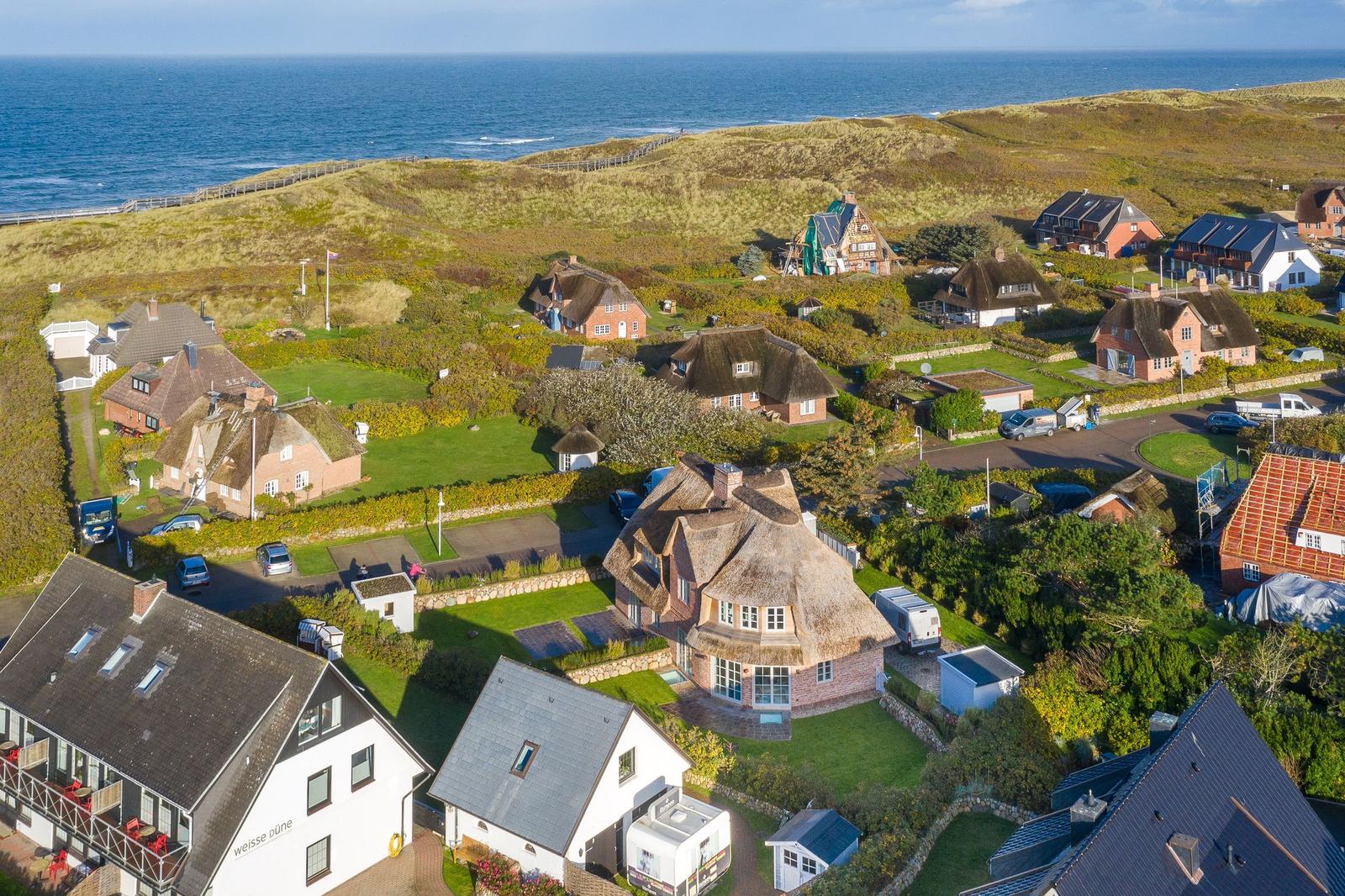 Dorfhäuser mit Strohdächern am Strand