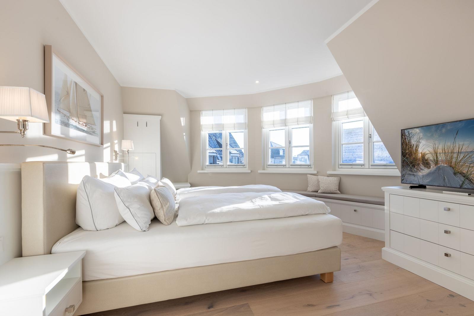 Schlafzimmer mit Doppelbett, Fensterbank und Fernseher