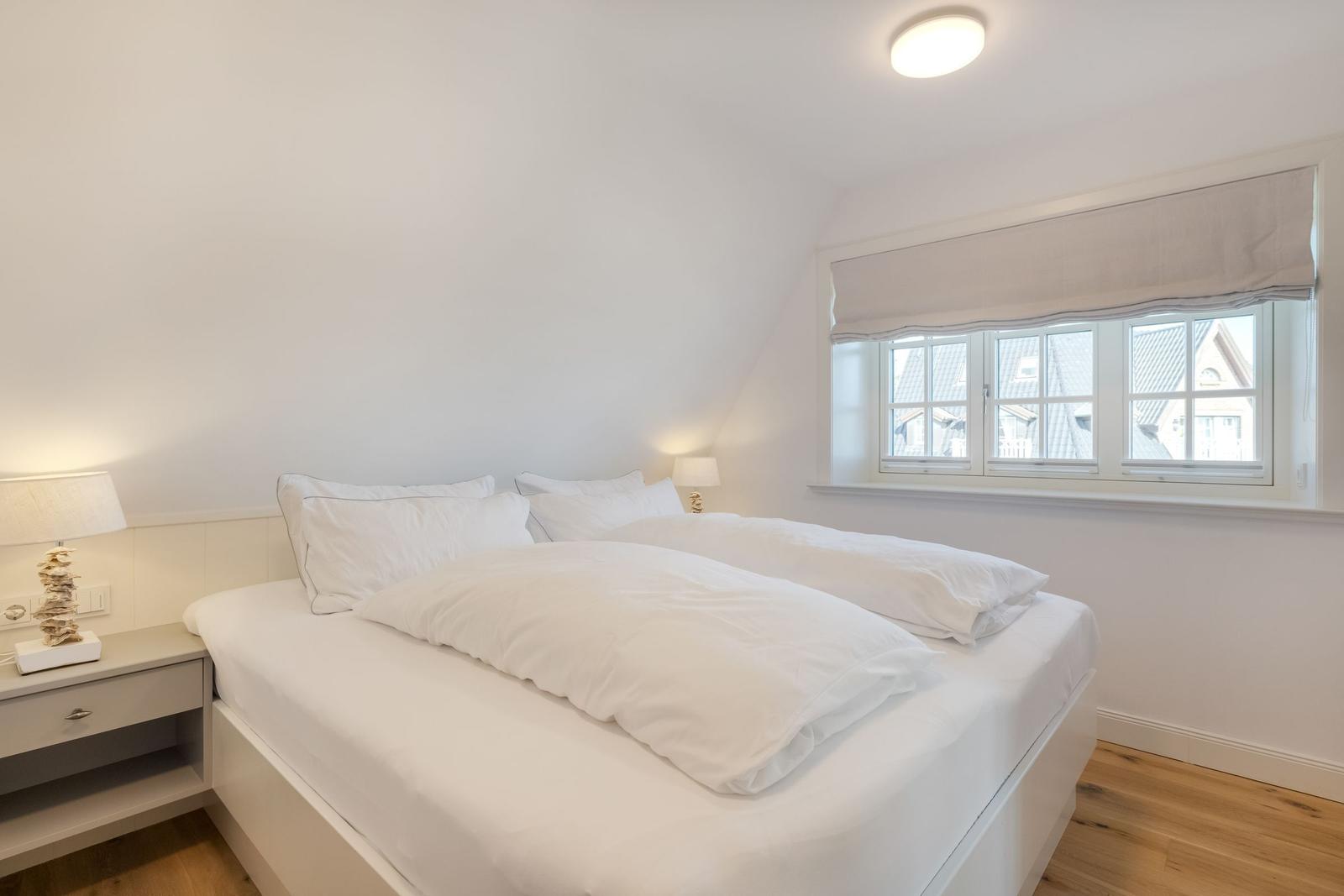 Schlafzimmer mit Doppelbett, Fenster und Nachttisch