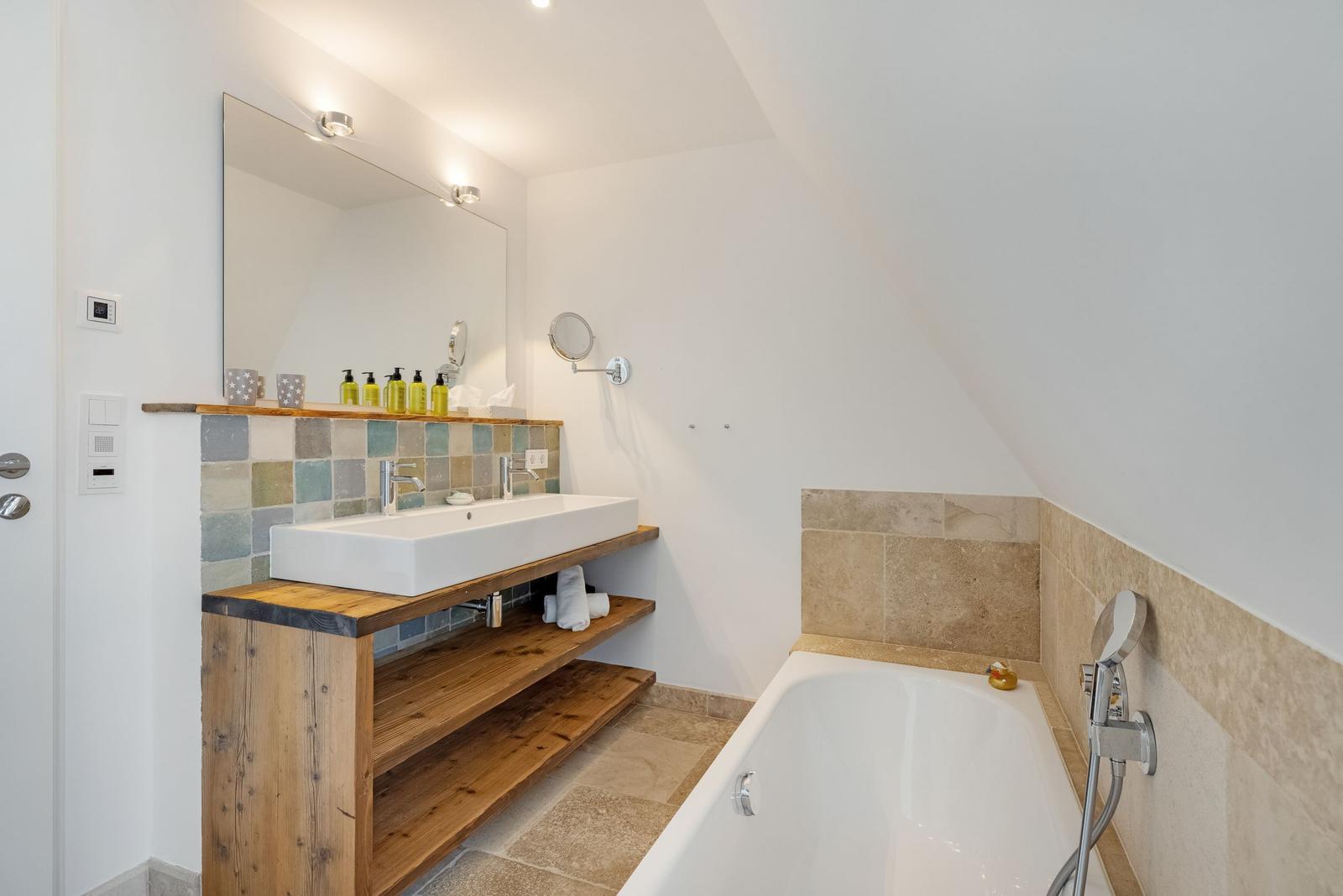 Badezimmer mit Badewanne, Waschbecken und Spiegel