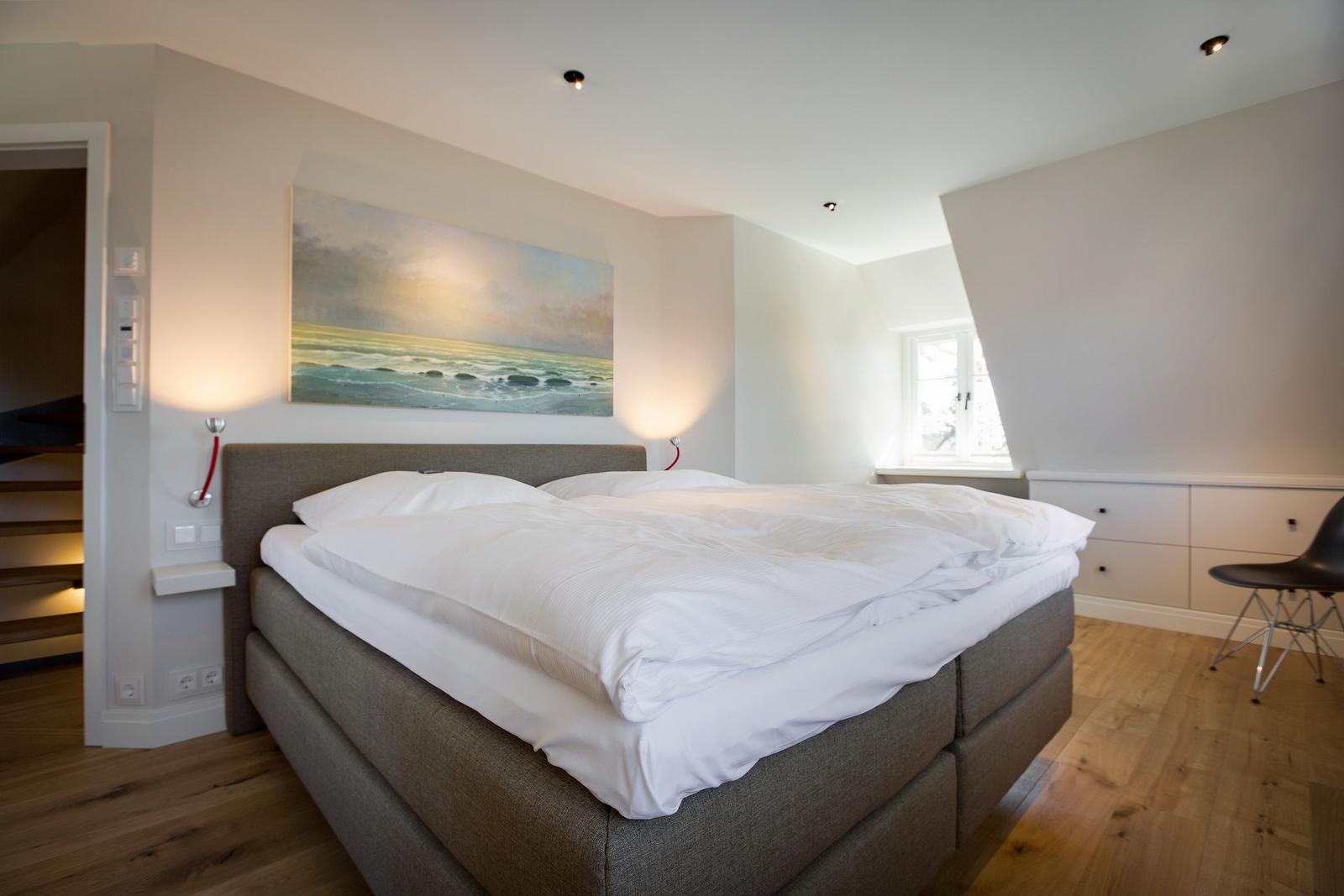 Bedroom with bed, wall art, and window