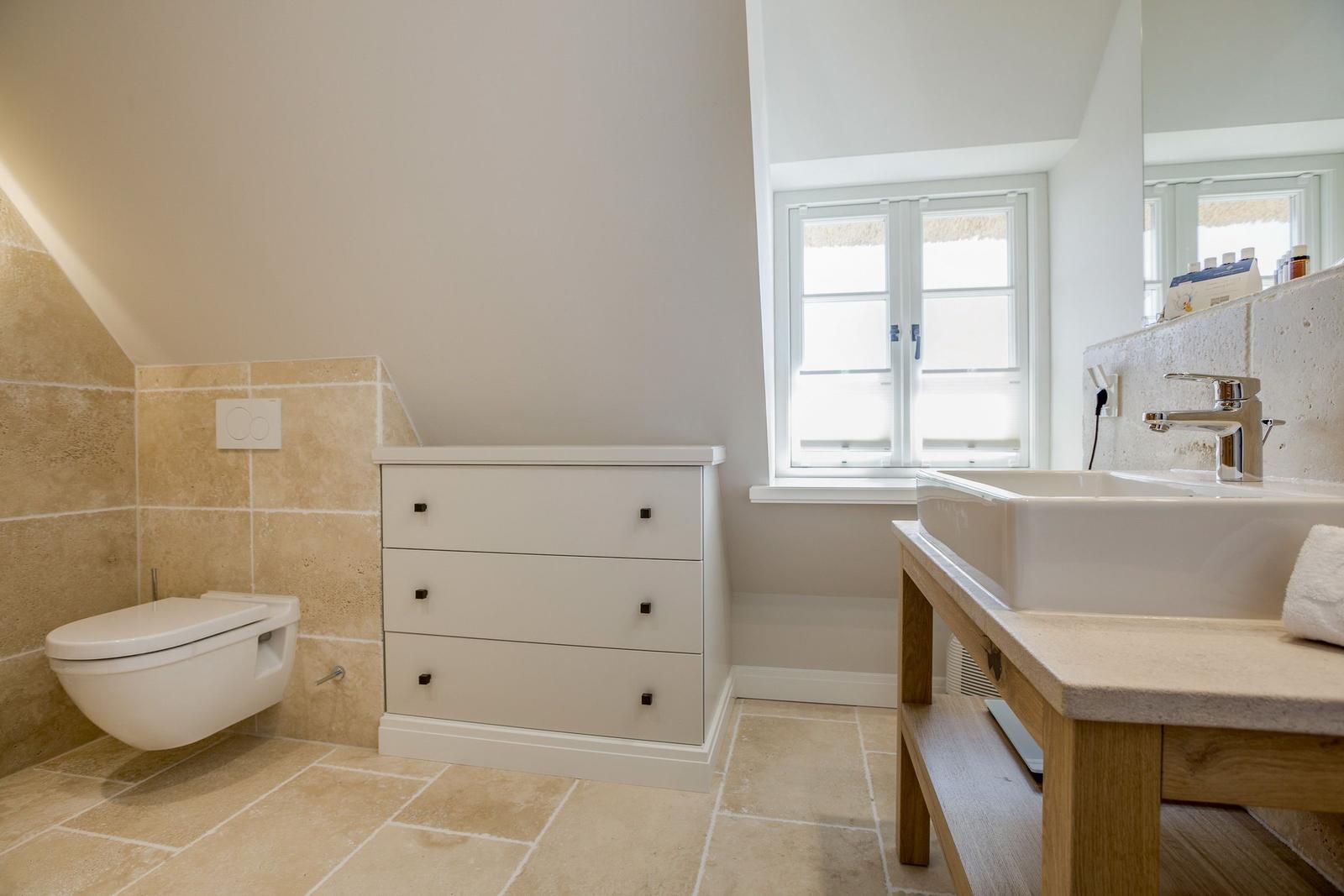 Bathroom with sink, toilet, and cabinet