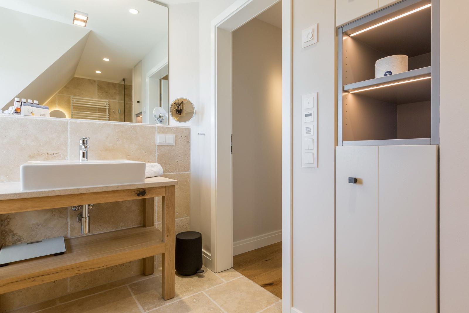 Bathroom with sink, mirror cabinet, and lit shelf