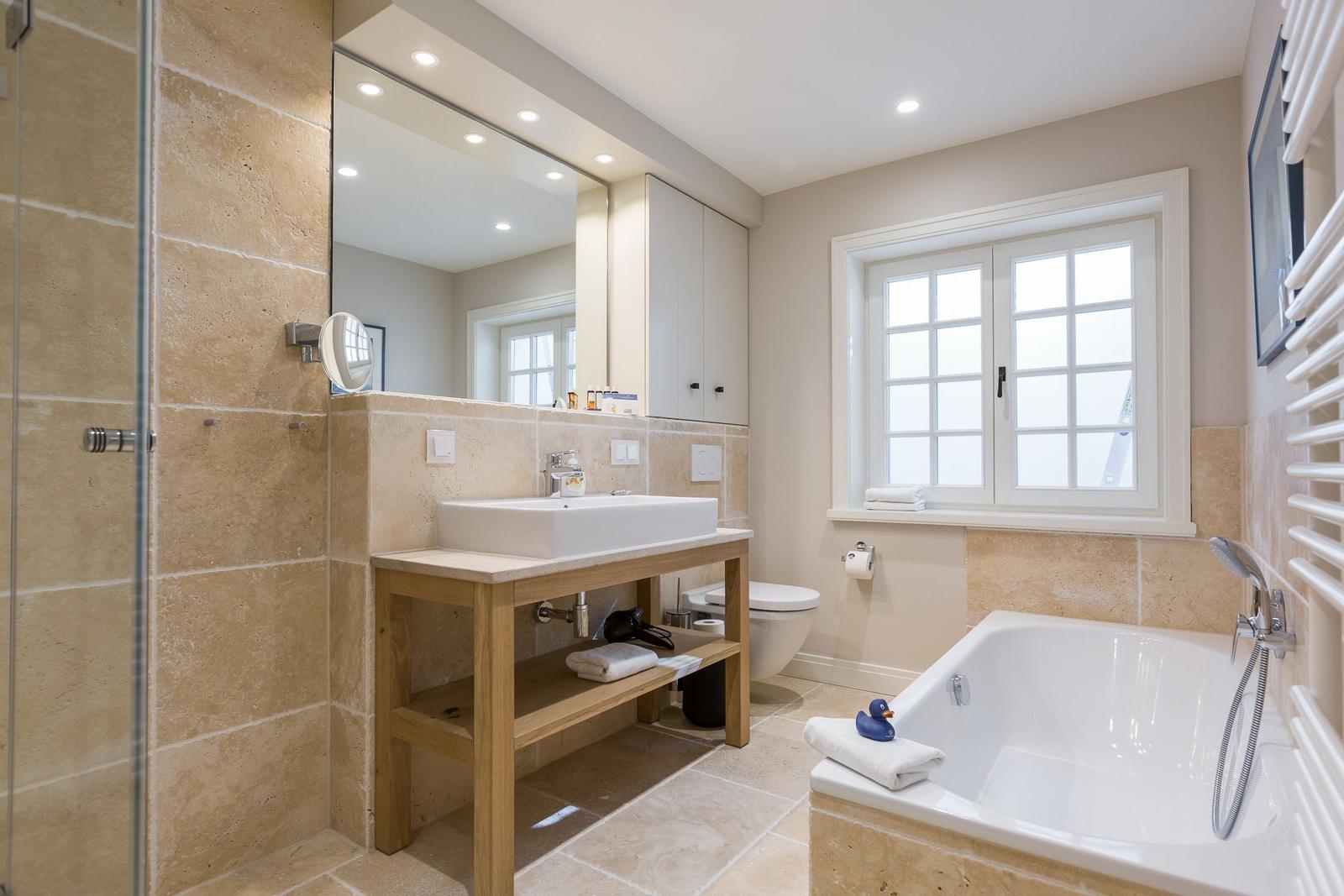 Bathroom with shower, bathtub, sink, and window