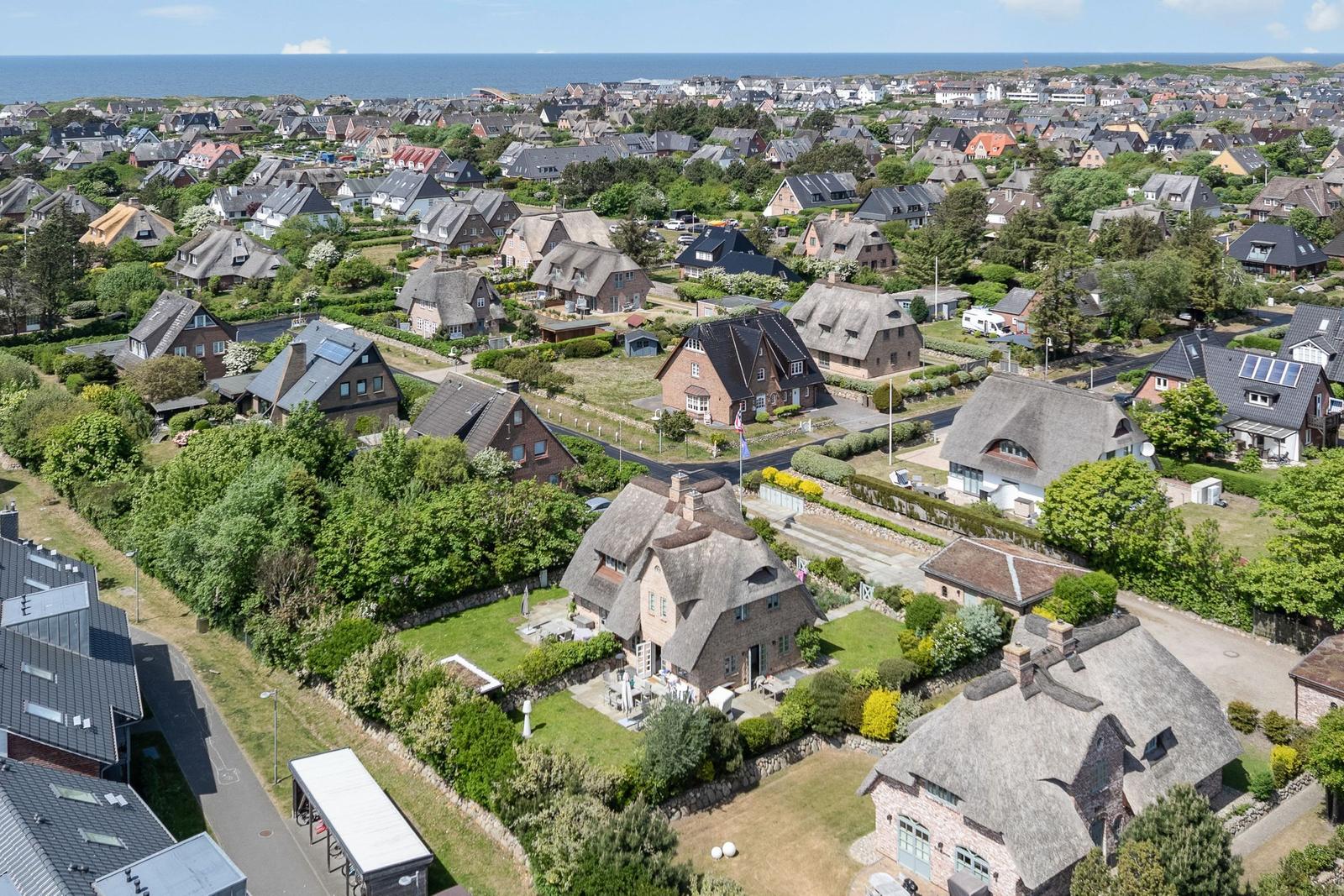 Village with thatched houses and view of the sea