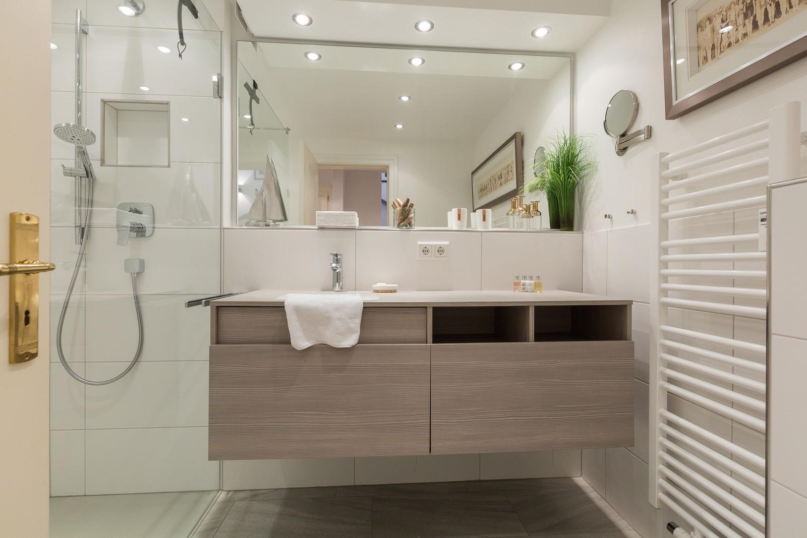 Badezimmer mit Dusche, Waschtisch und Spiegel