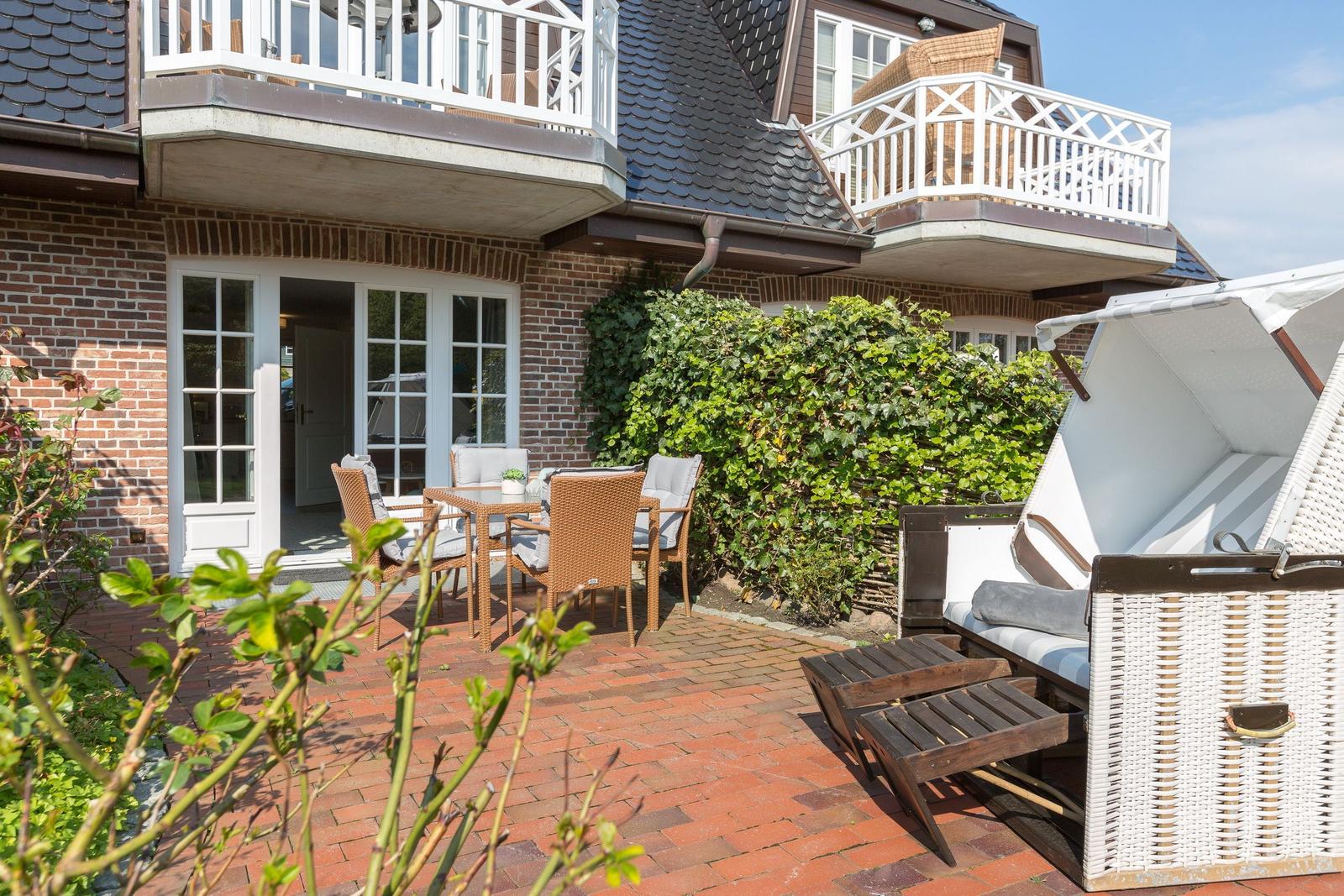 Terrasse mit Sitzgruppe, Strandkorb und Blick auf das Haus.