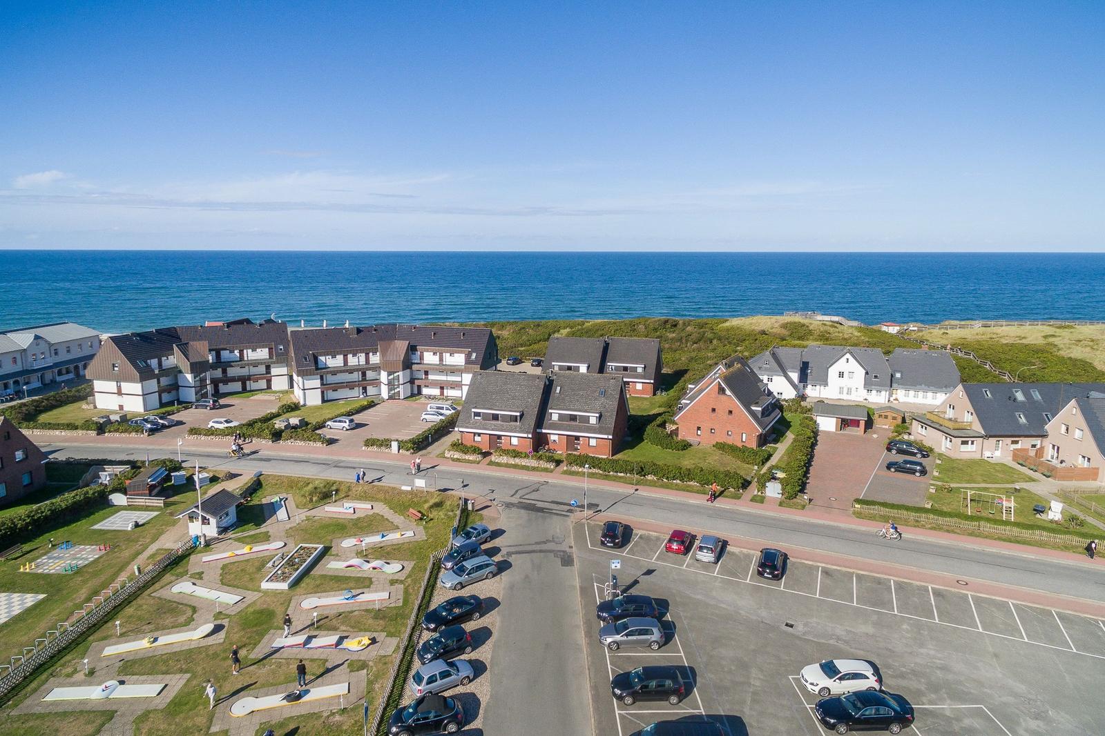 Coastal holiday complex with parking lots and mini golf course.