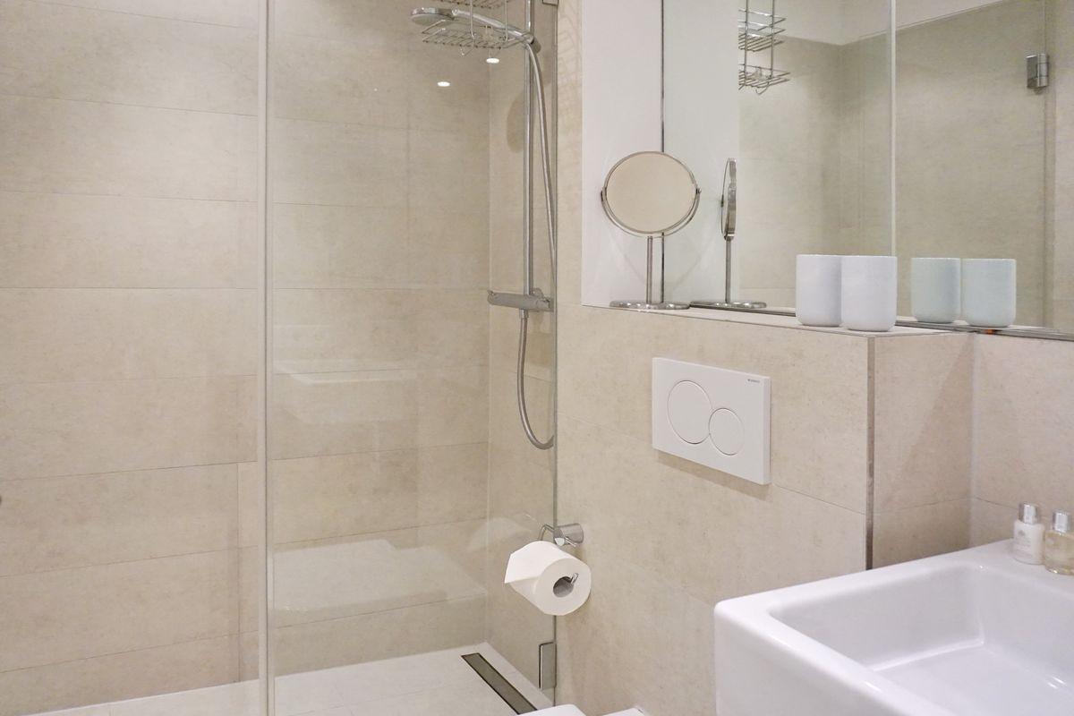 Bathroom with shower, sink, and mirror