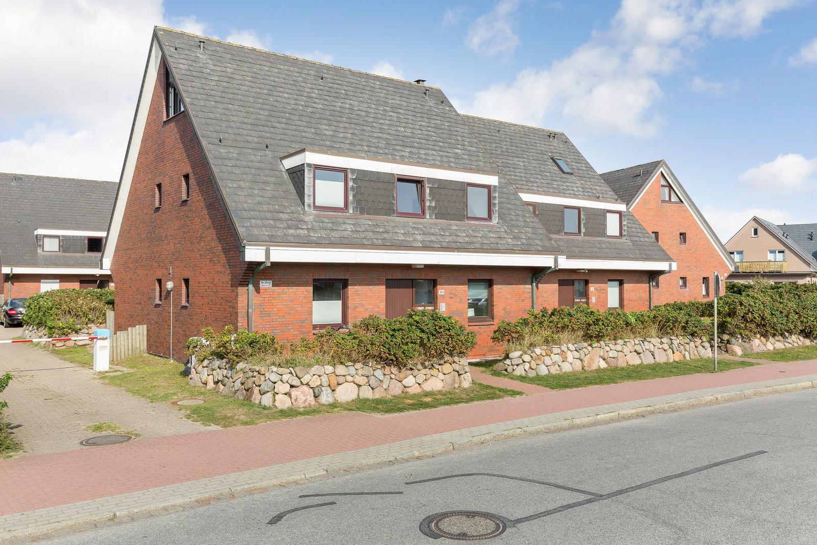 Red brick house with gray roof and windows on street