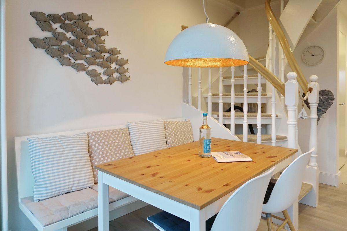 Dining area with wooden table, bench, and wall decor of fish.