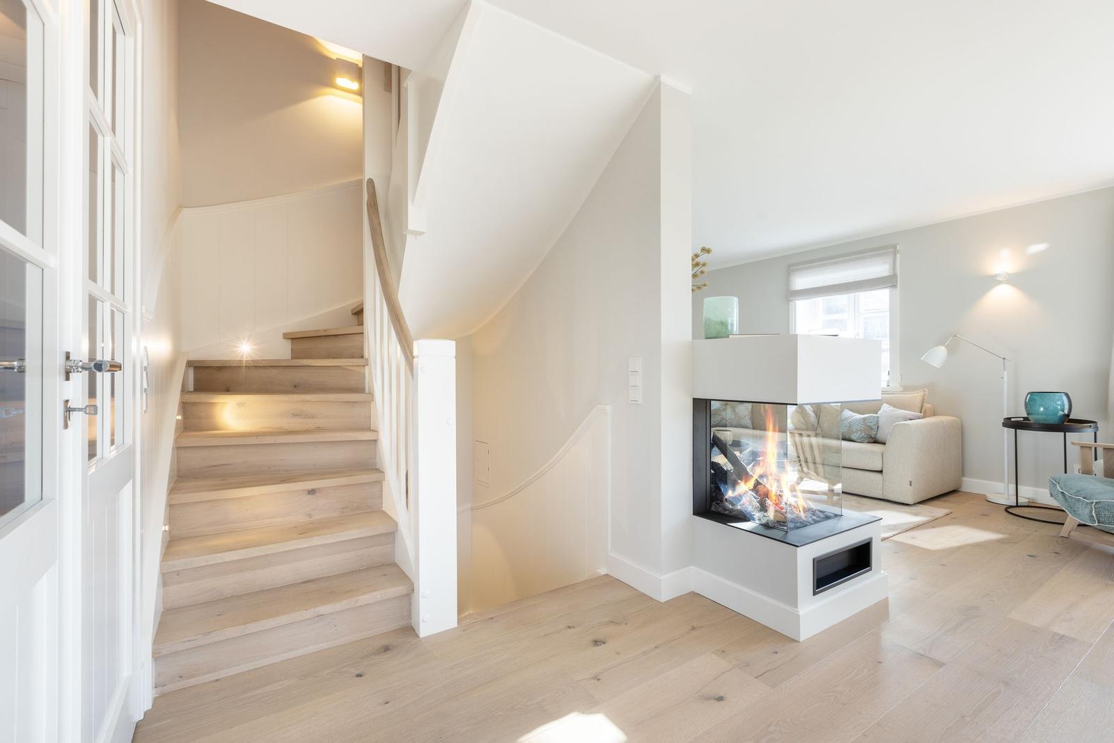 Haus mit Holztreppe und Kamin im Wohnzimmer.