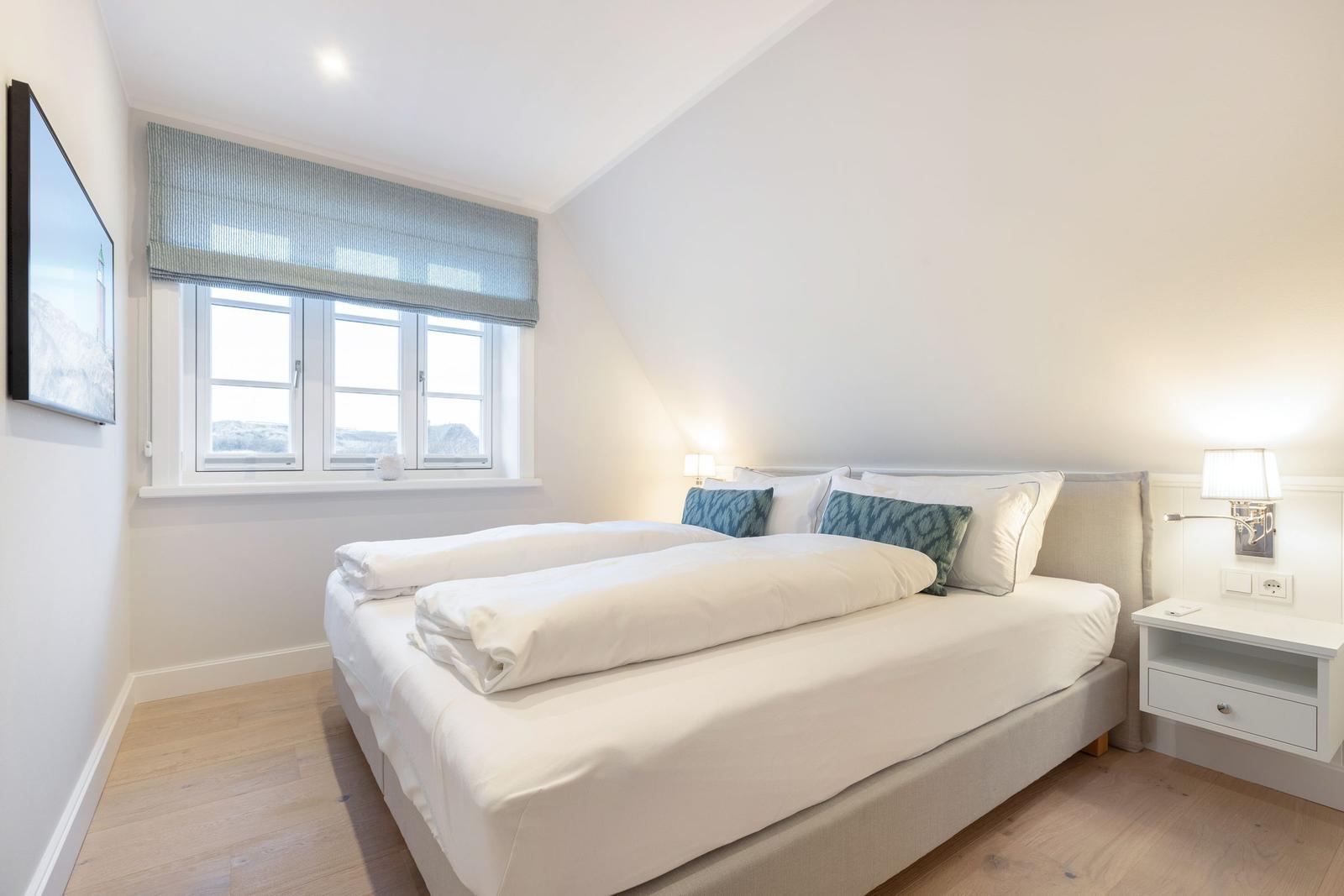 Schlafzimmer mit Doppelbett, Fenster und Nachttisch