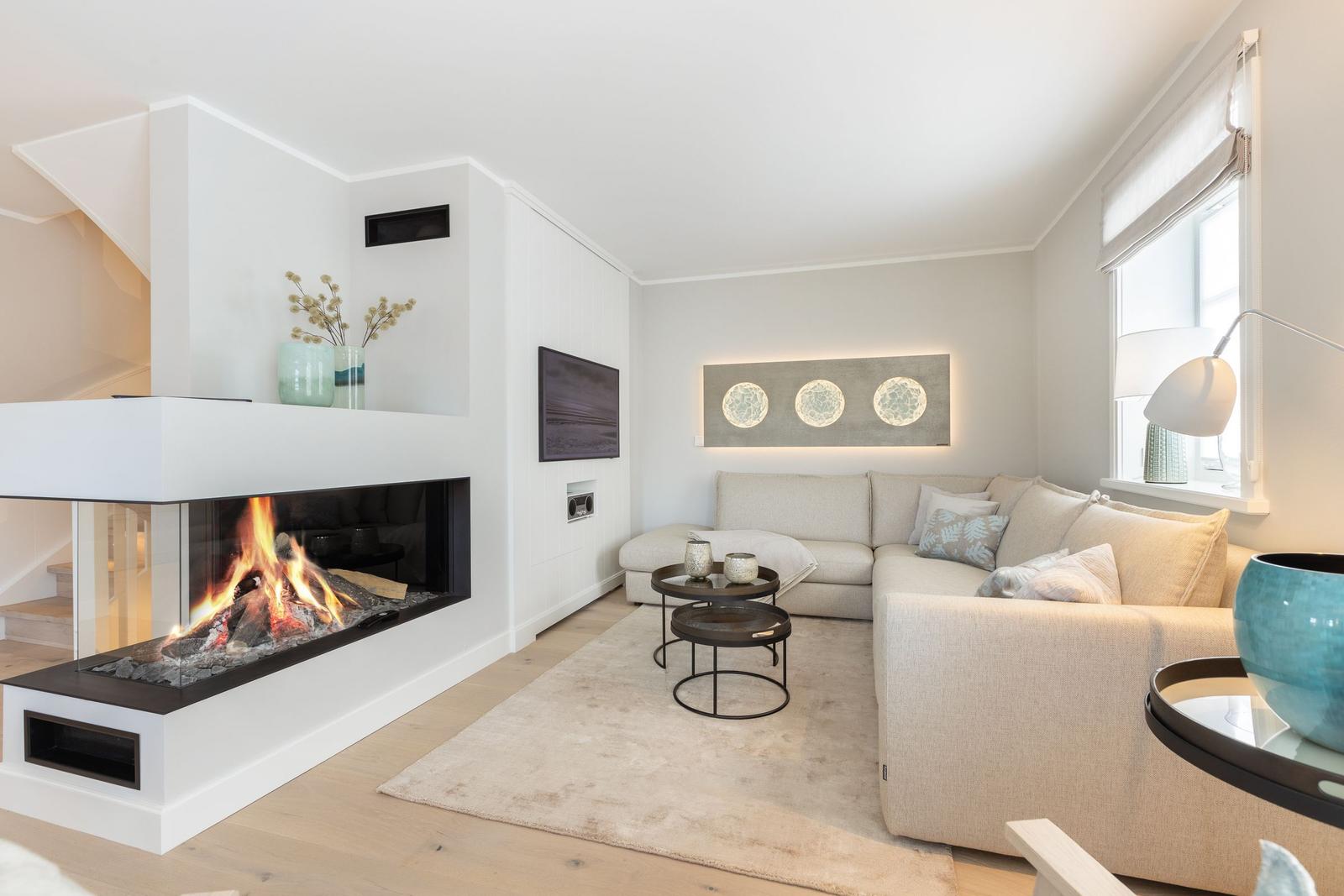 Wohnzimmer mit Kamin, Sofa und Wandbild.