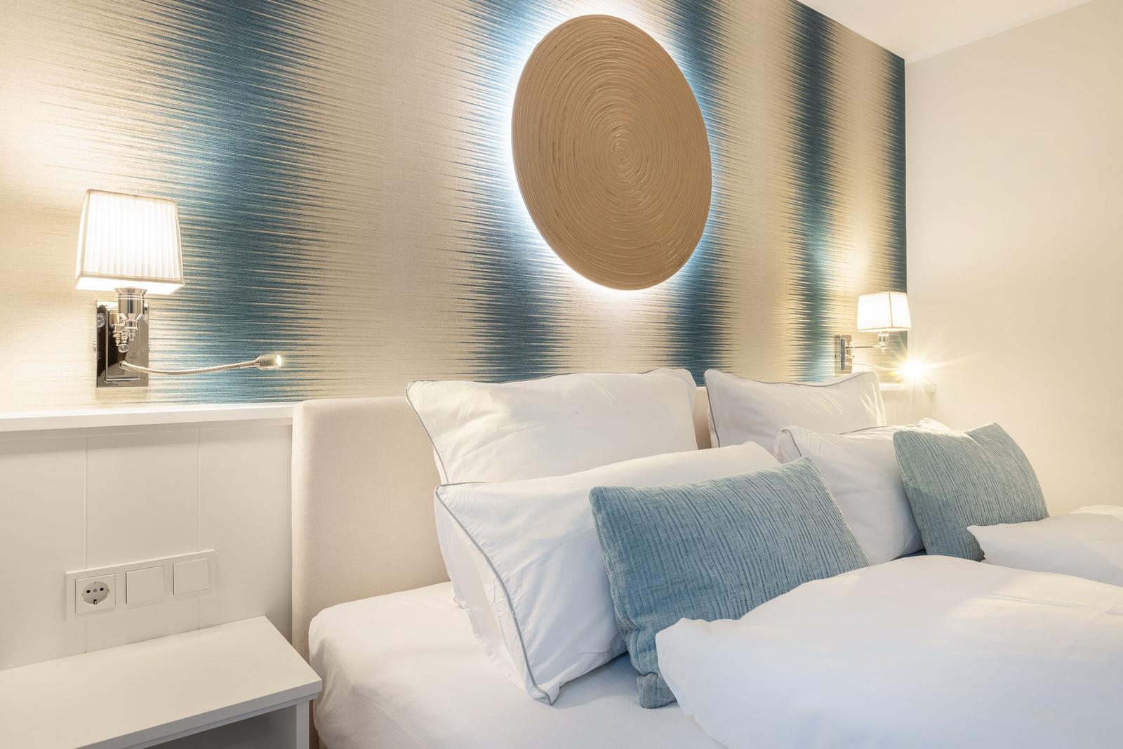Schlafzimmer mit Bett, Kissen und Wanddekoration.