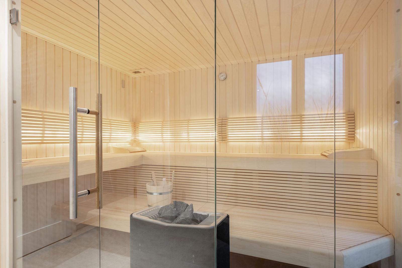 Sauna mit Holzwand, Sitzbänken und Steinkachel