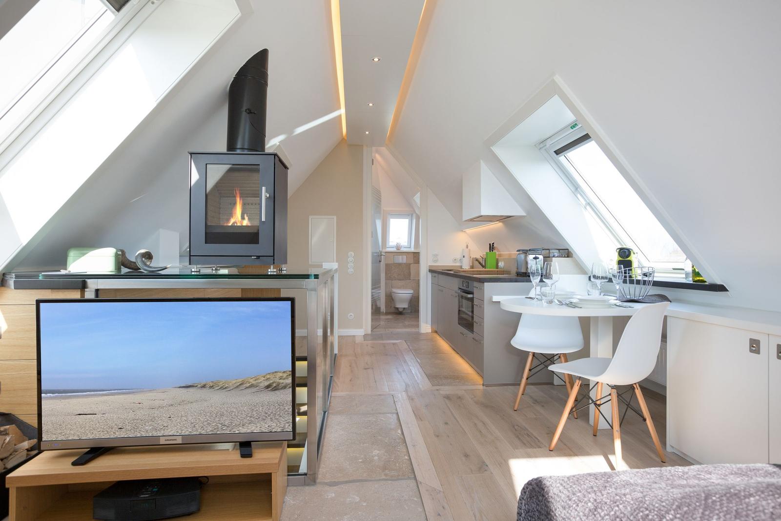 Wohnküche mit Kamin, Esstisch und Dachfenstern