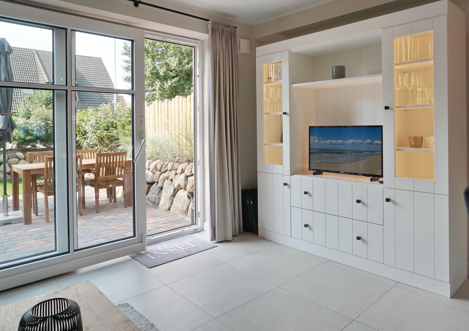 Living room with TV, wine cabinet, and terrace access