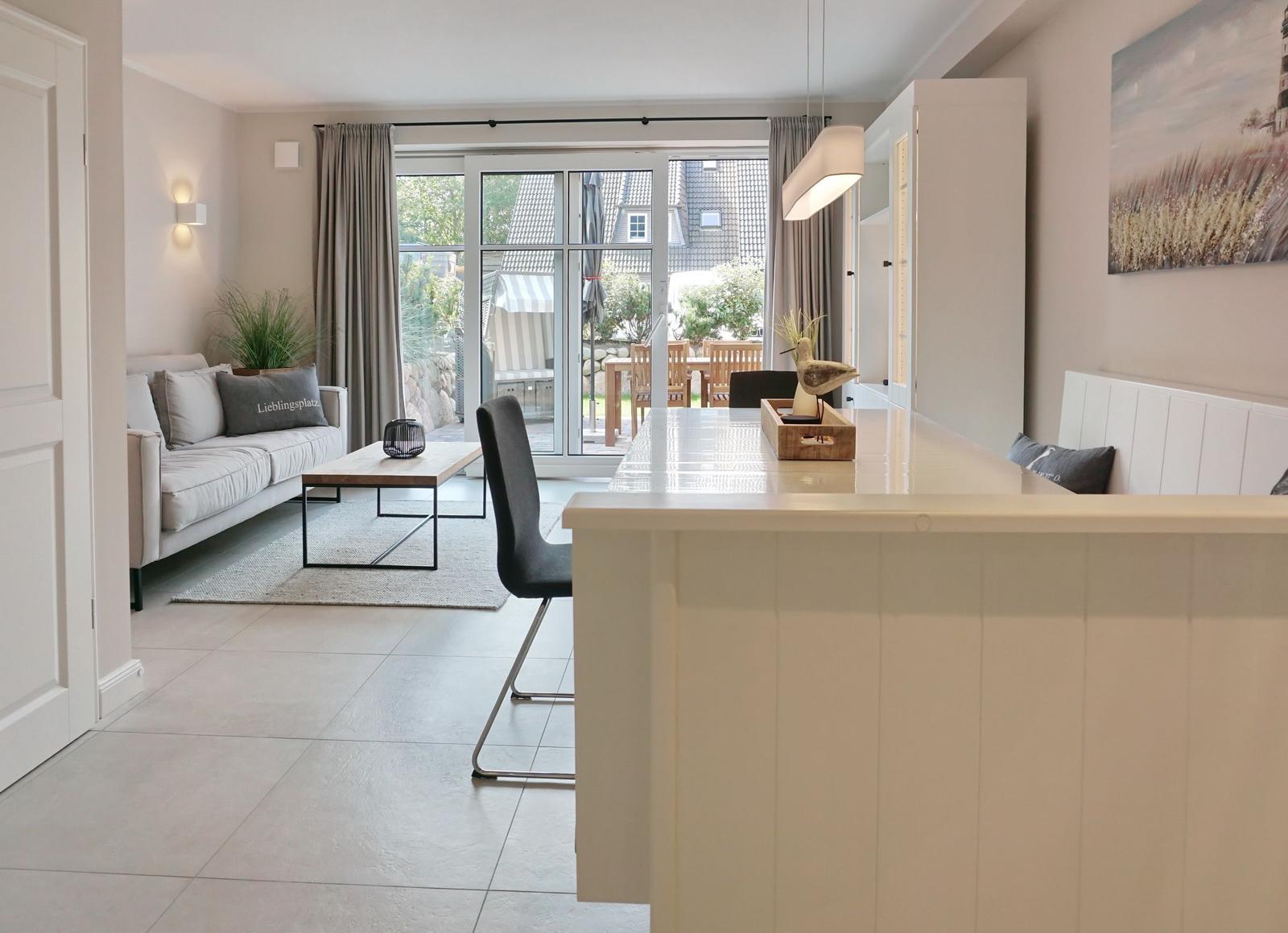Living and dining area with modern furniture and view of the garden.