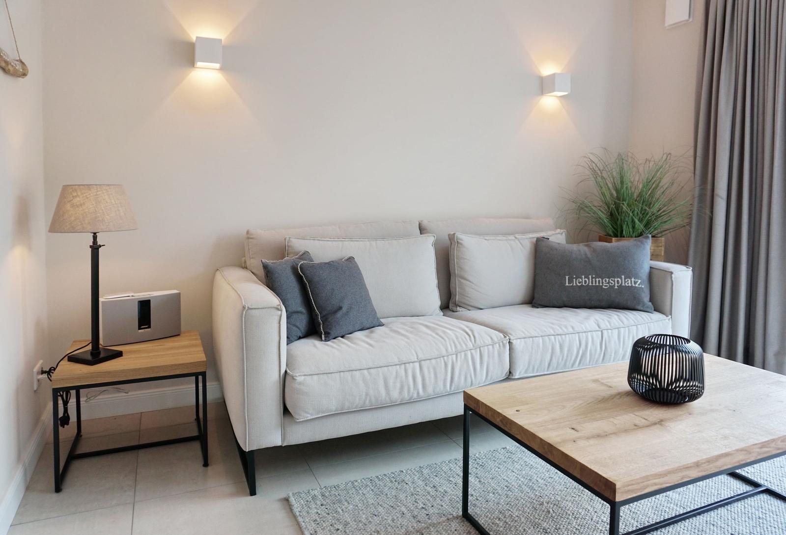 A living room with sofa, coffee table, and lighting.