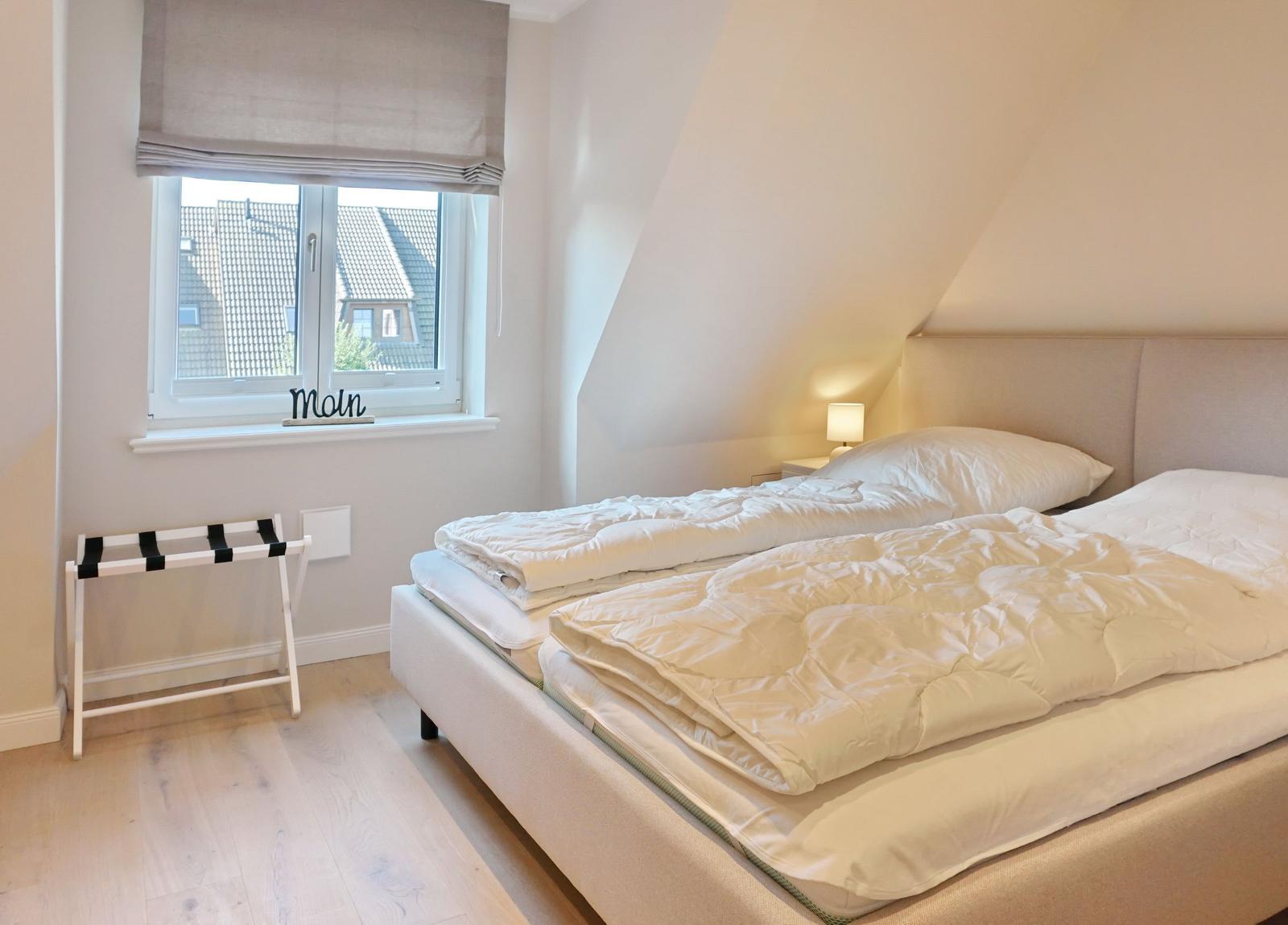 Bedroom with double bed, window, and standing rack.