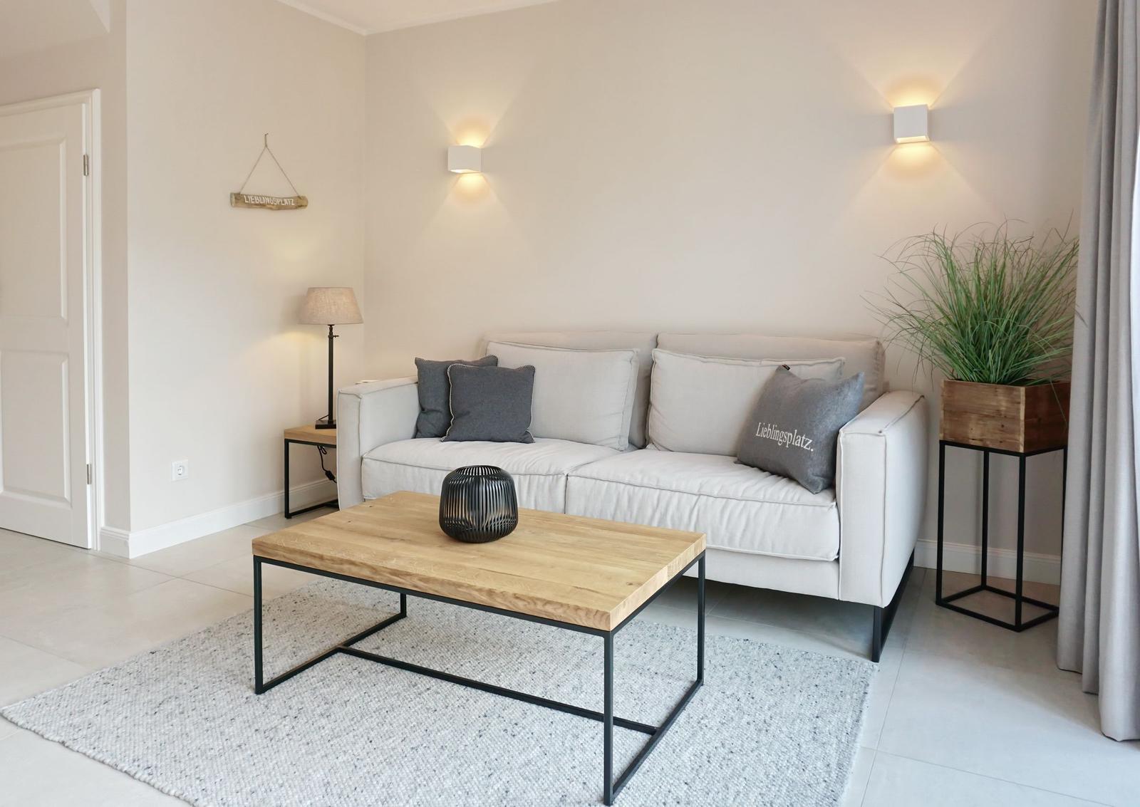 Living room with sofa, coffee table, and plant.