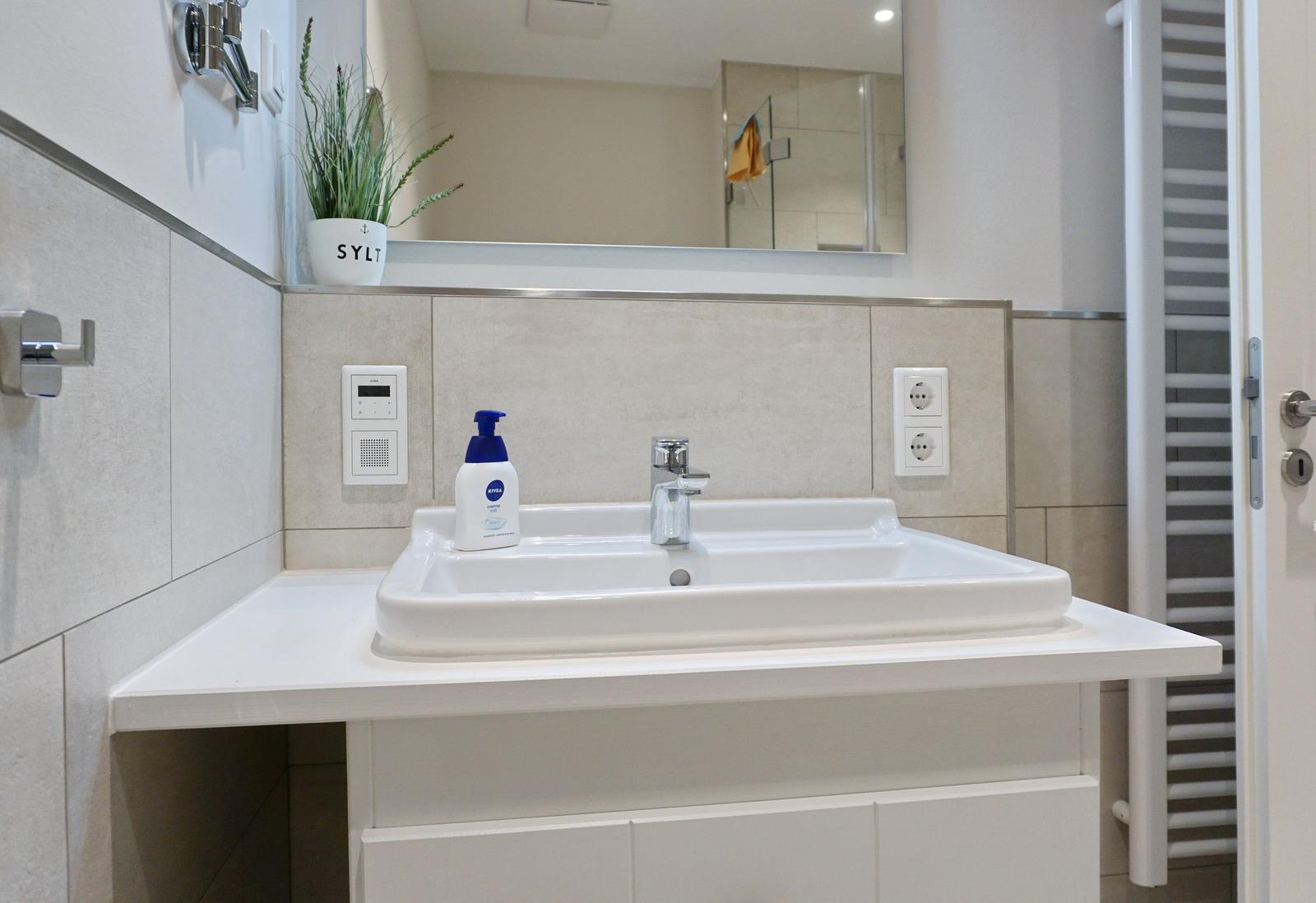 Bathroom with sink, mirror, and plant