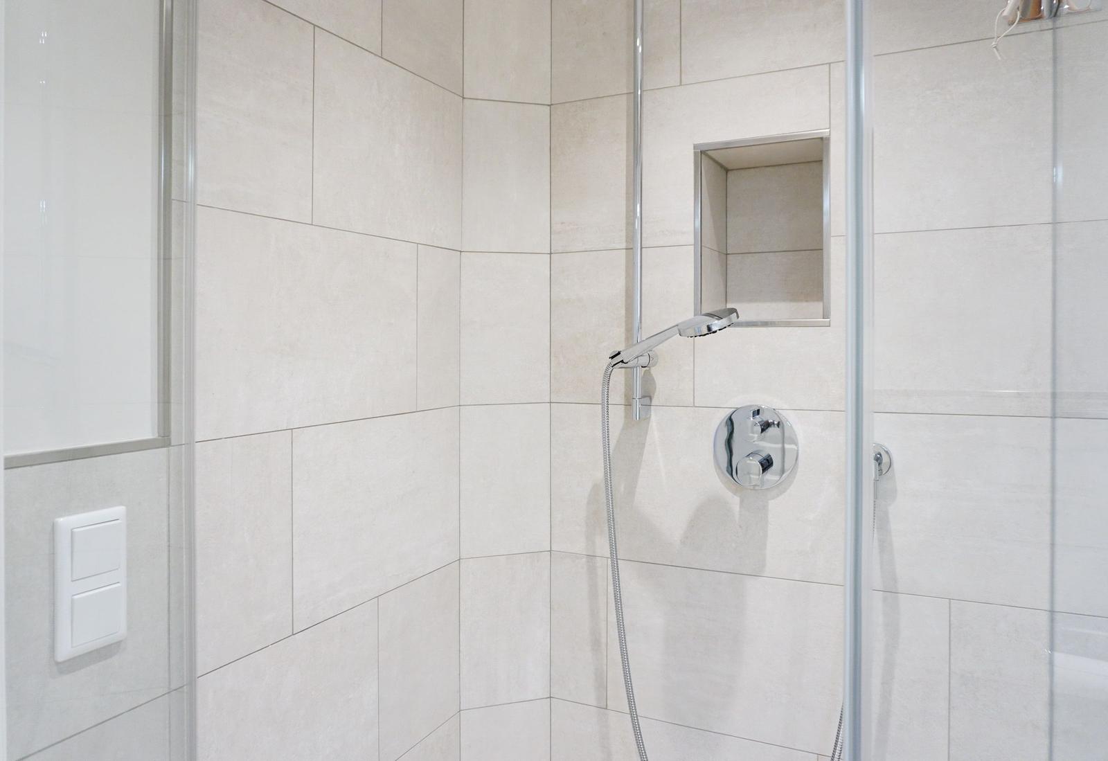 Shower cabin with glass door and chrome shower head