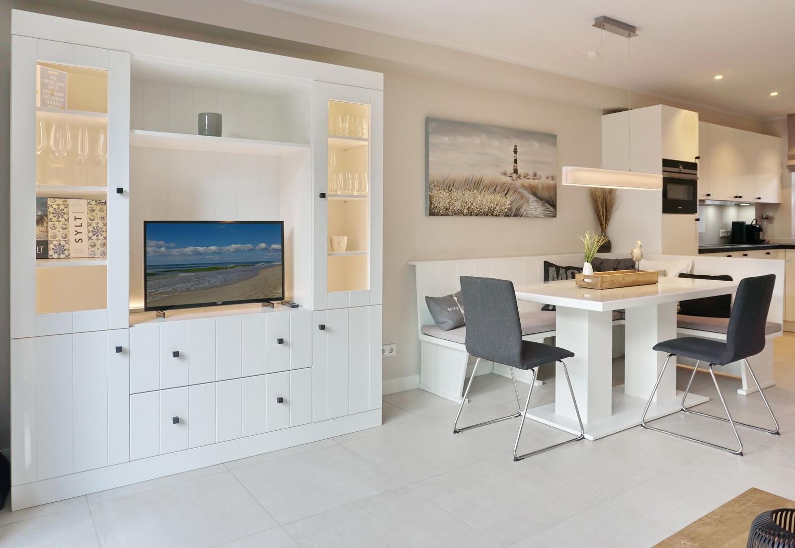 Living and dining area with TV, dining table, and kitchen.