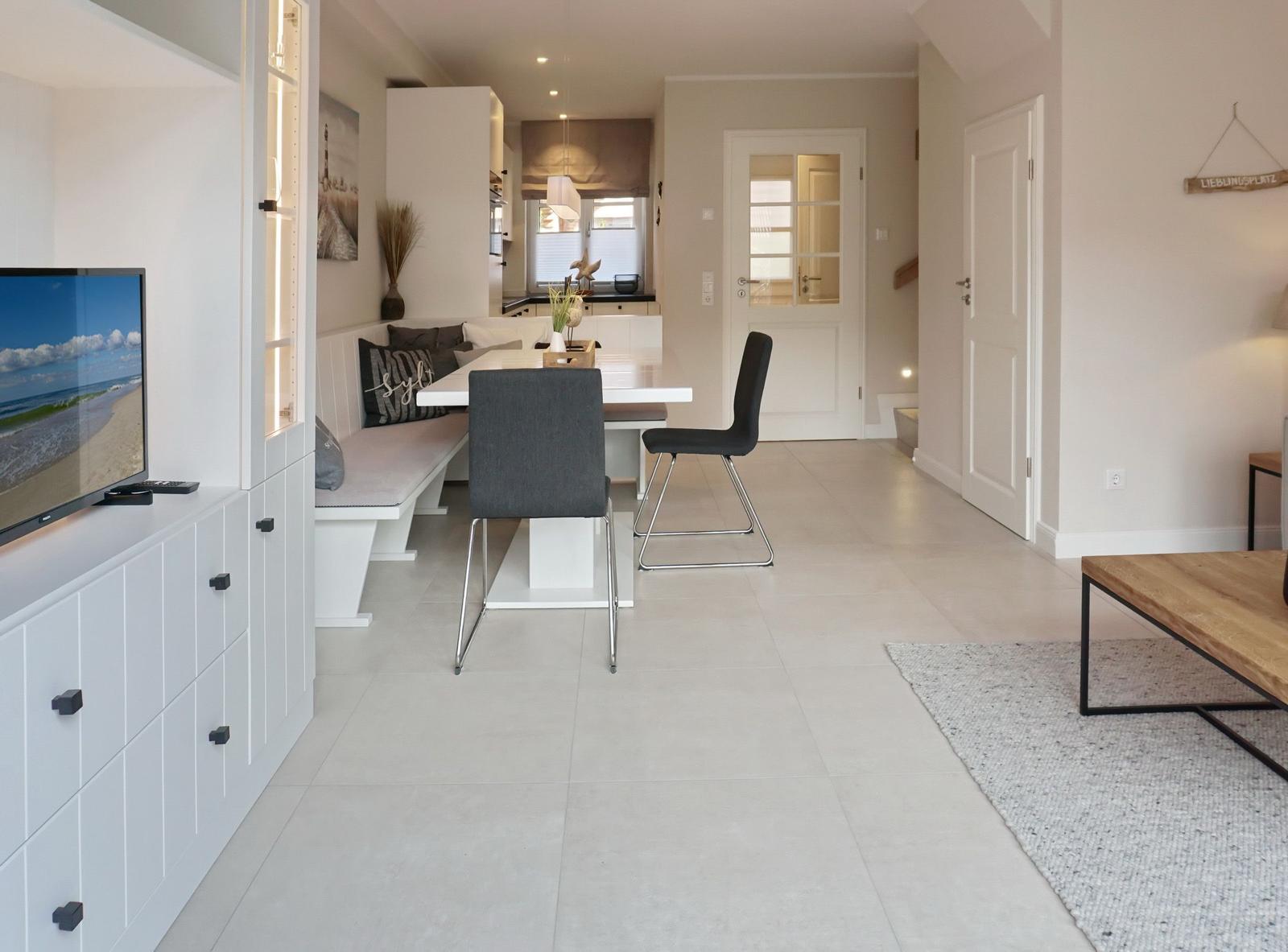 Living and dining area with TV, dining table, and kitchen area
