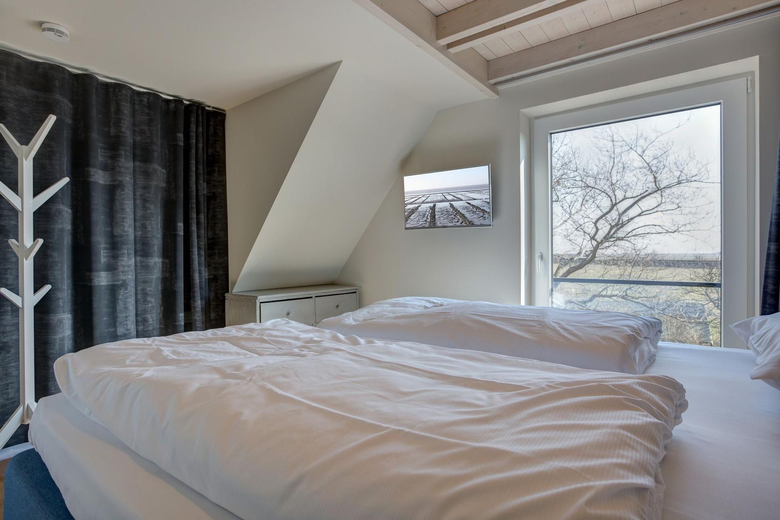 Schlafzimmer mit Doppelbett, Fenster und Wandbild