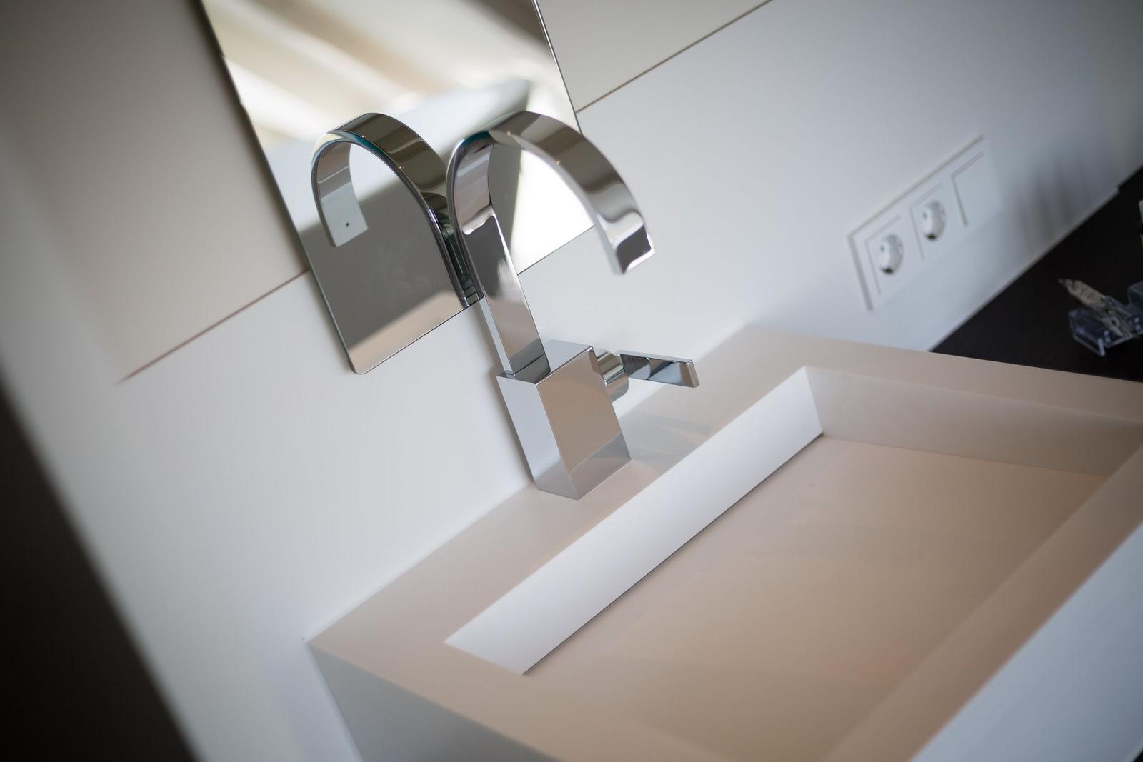 Moderne Waschbecken mit Chromarmatur und Spiegel
