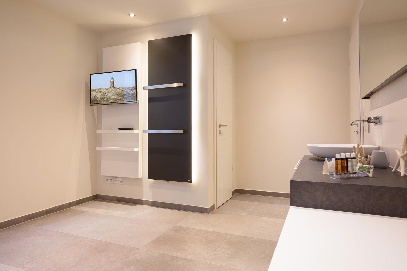 Moderne Dusche mit integriertem Fernseher und Waschtisch mit Keramikschale.