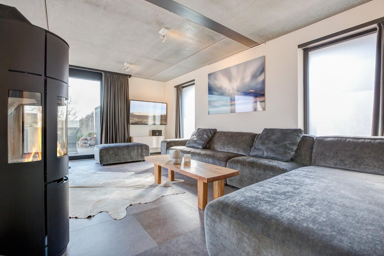 Wohnzimmer mit Sofa, Kamin und Fernseher