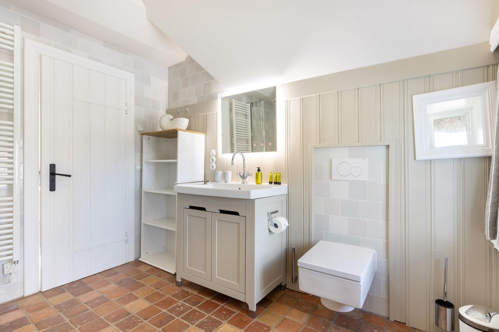 Badezimmer mit Waschbecken, Toilette und Spiegel