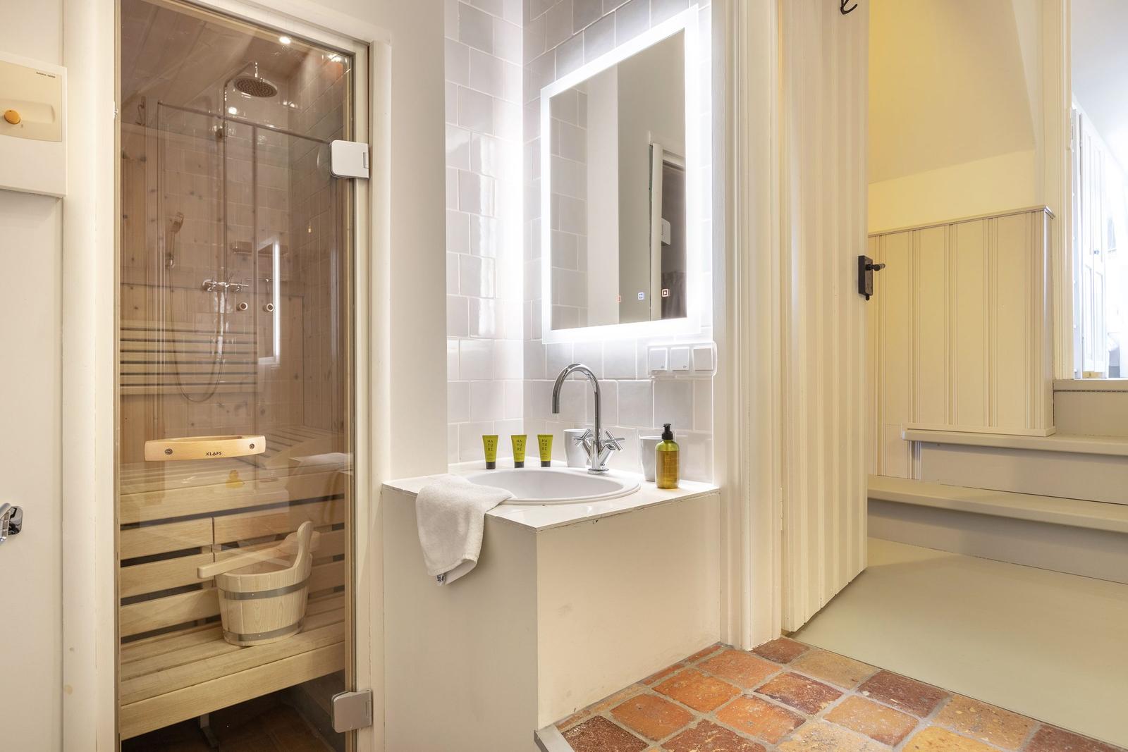 Badezimmer mit Dusche, Waschbecken und Spiegel