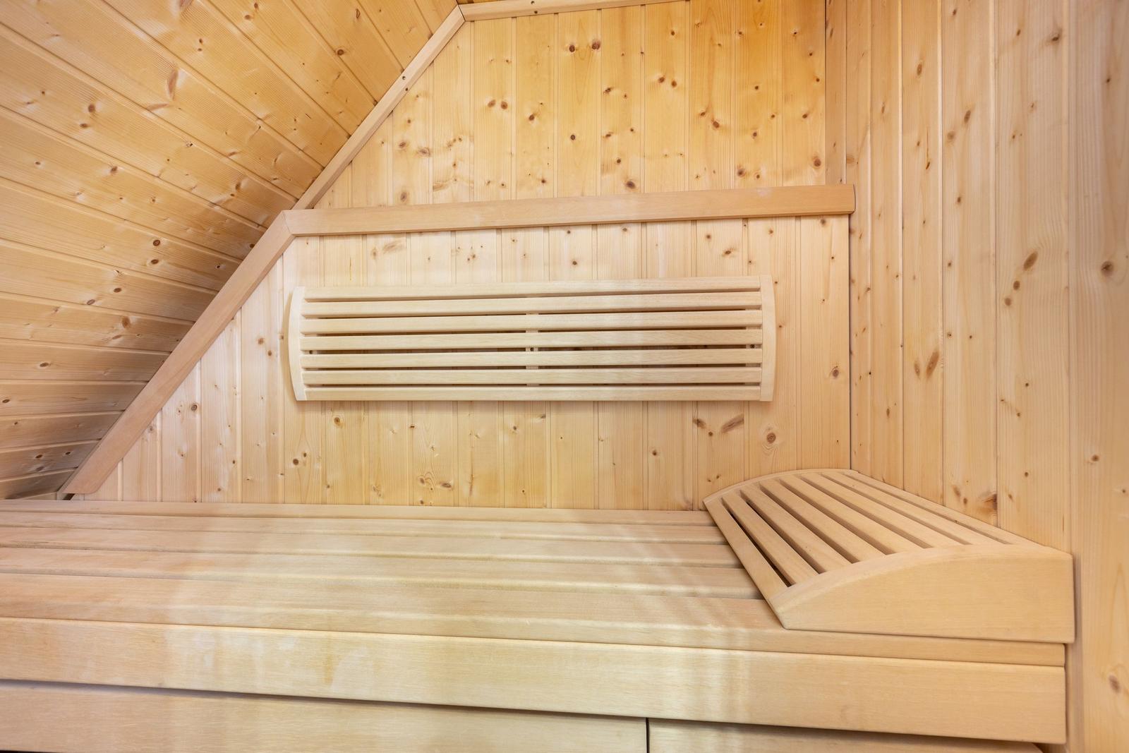 Holzsauna mit Sitzbank und Wärmekörper an der Wand.