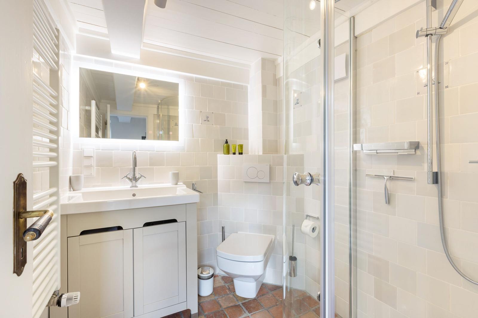 Bathroom with shower, toilet, and sink.