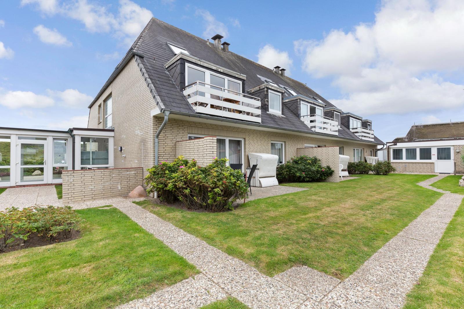 Holiday home with balconies and garden. Modern building with terrace and plants.