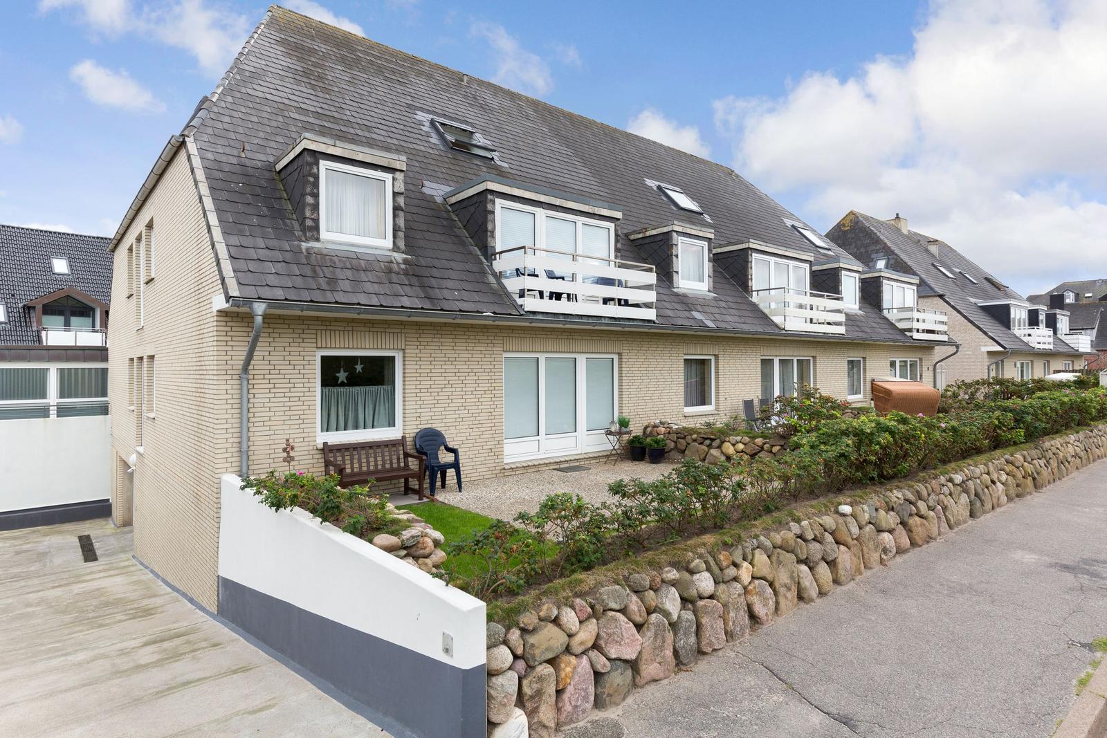 Holiday home with balconies and garden area on quiet street.