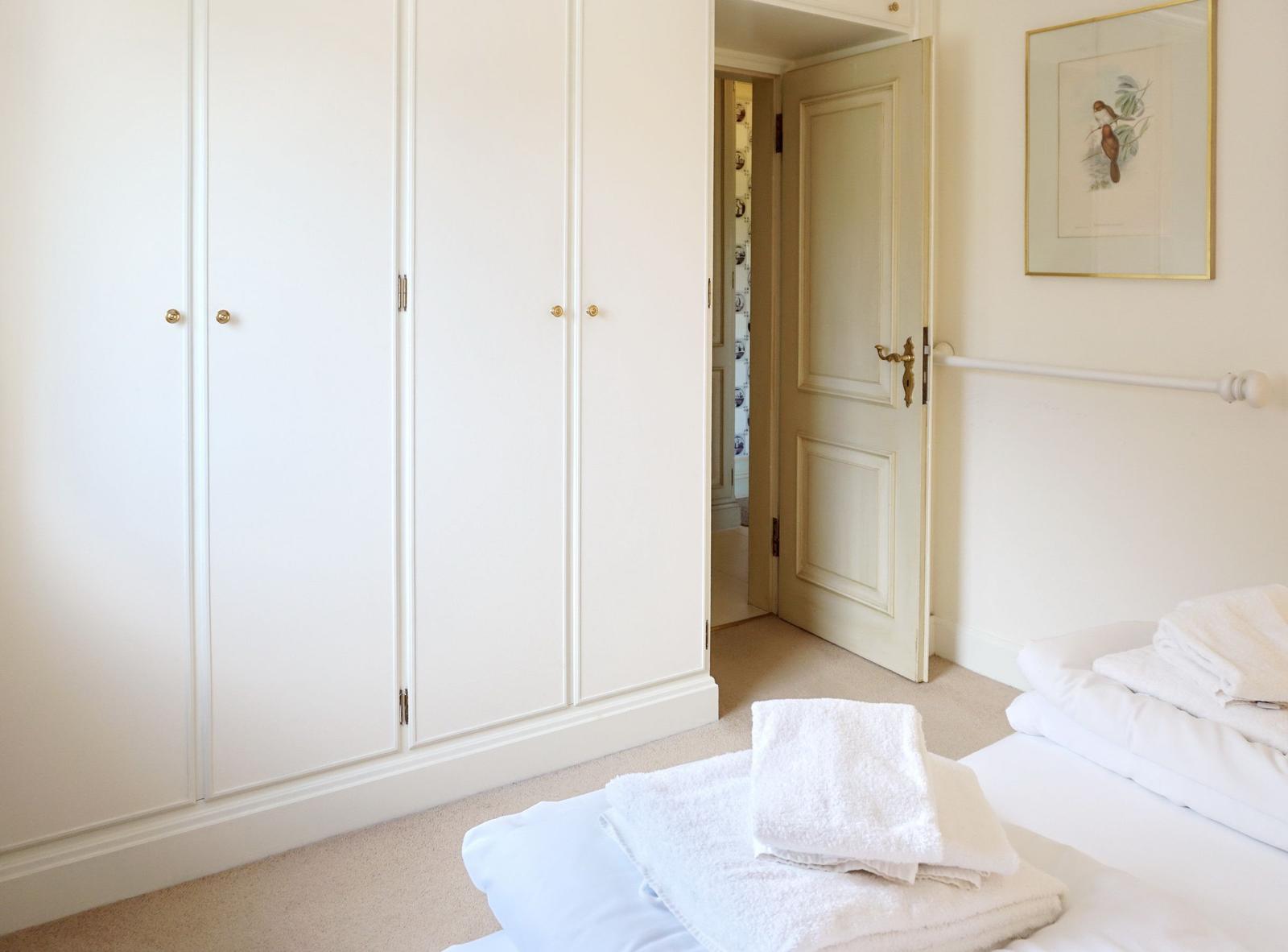 Schlafzimmer mit Kleiderschrank, Bett und Tür.