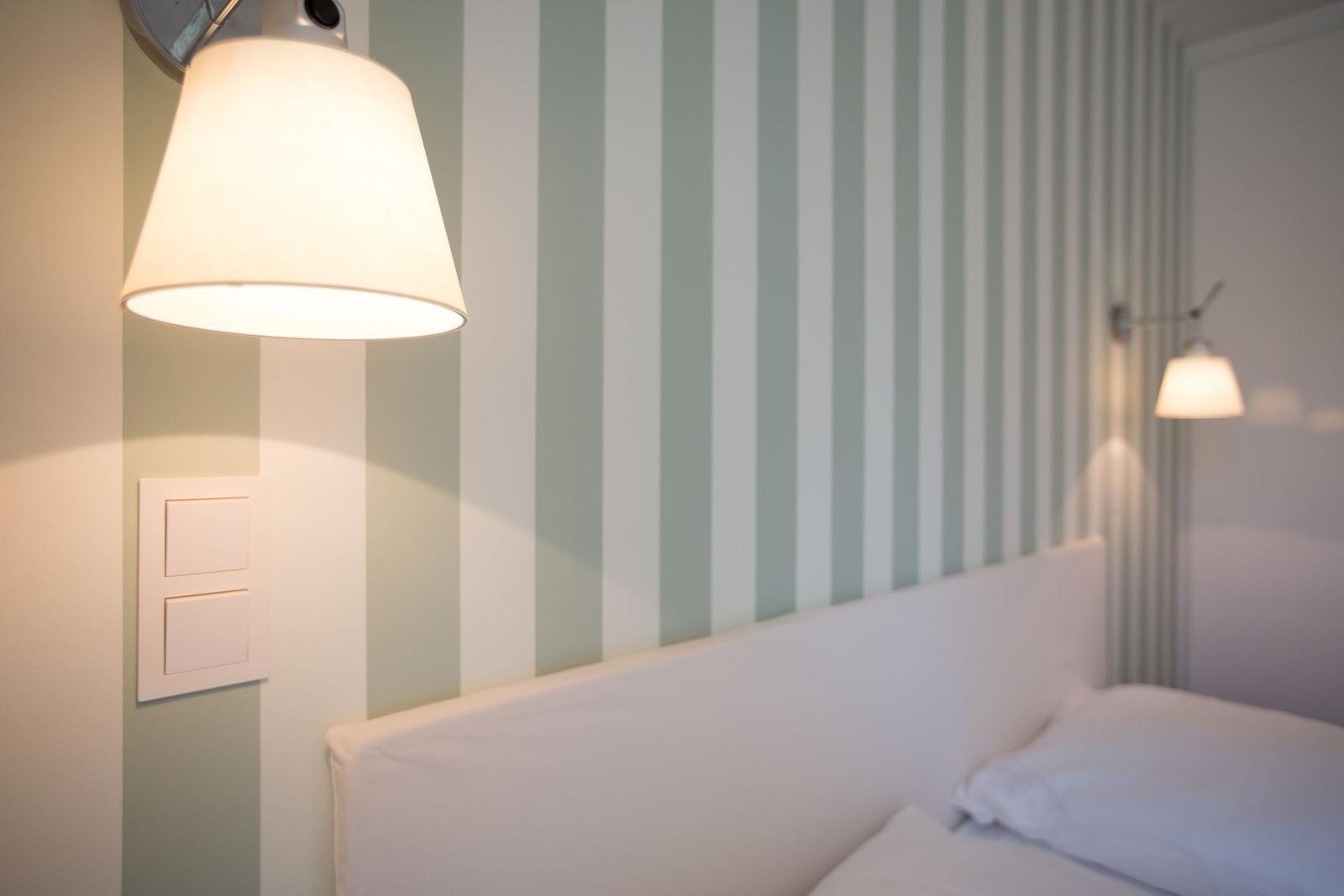 Schlafzimmer mit gestreifter Wand und Wandlampen